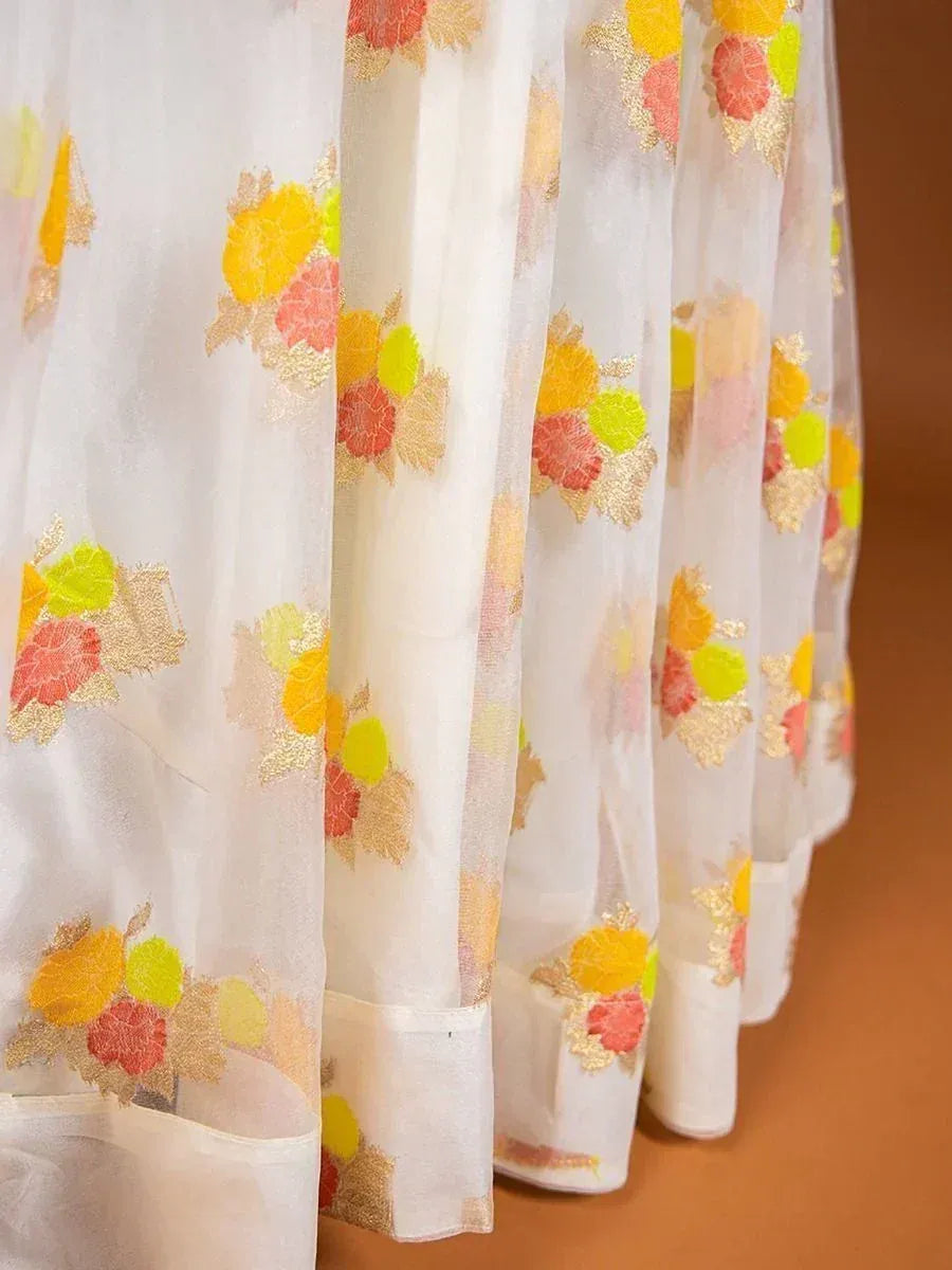 White sheer ethnic gown with vibrant floral embroidery in yellow, pink, and green