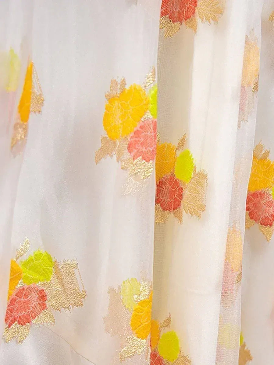 White ethnic gown with vibrant floral embroidery in yellow, pink, and gold for festive occasions