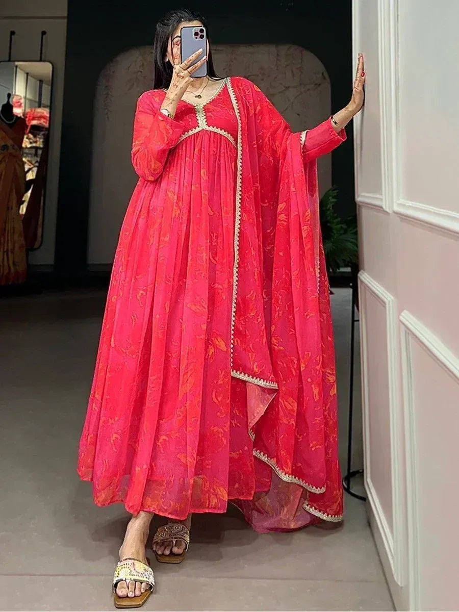 Vibrant pink floral ethnic gown with gold trim, perfect for Indian occasions and festive wear.