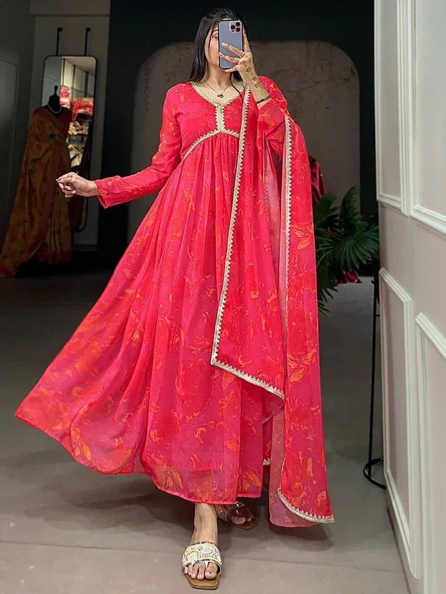Vibrant red floral printed ethnic gown with gold trim, perfect for Indian occasions and festive wear.