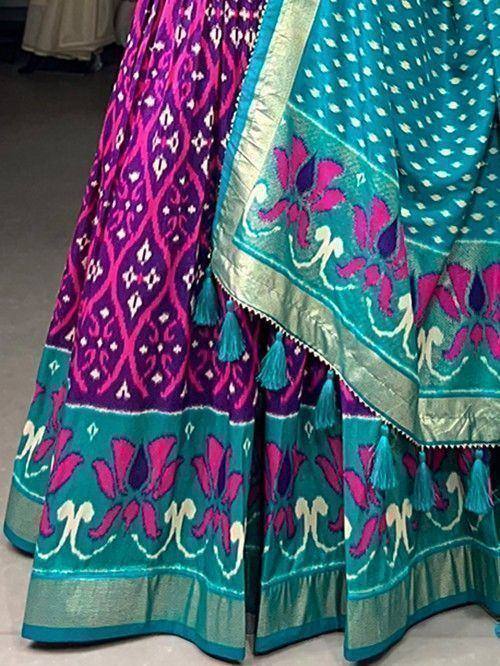 Vibrant purple and teal lehenga choli with floral embroidery and tassels, ethnic Indian wear