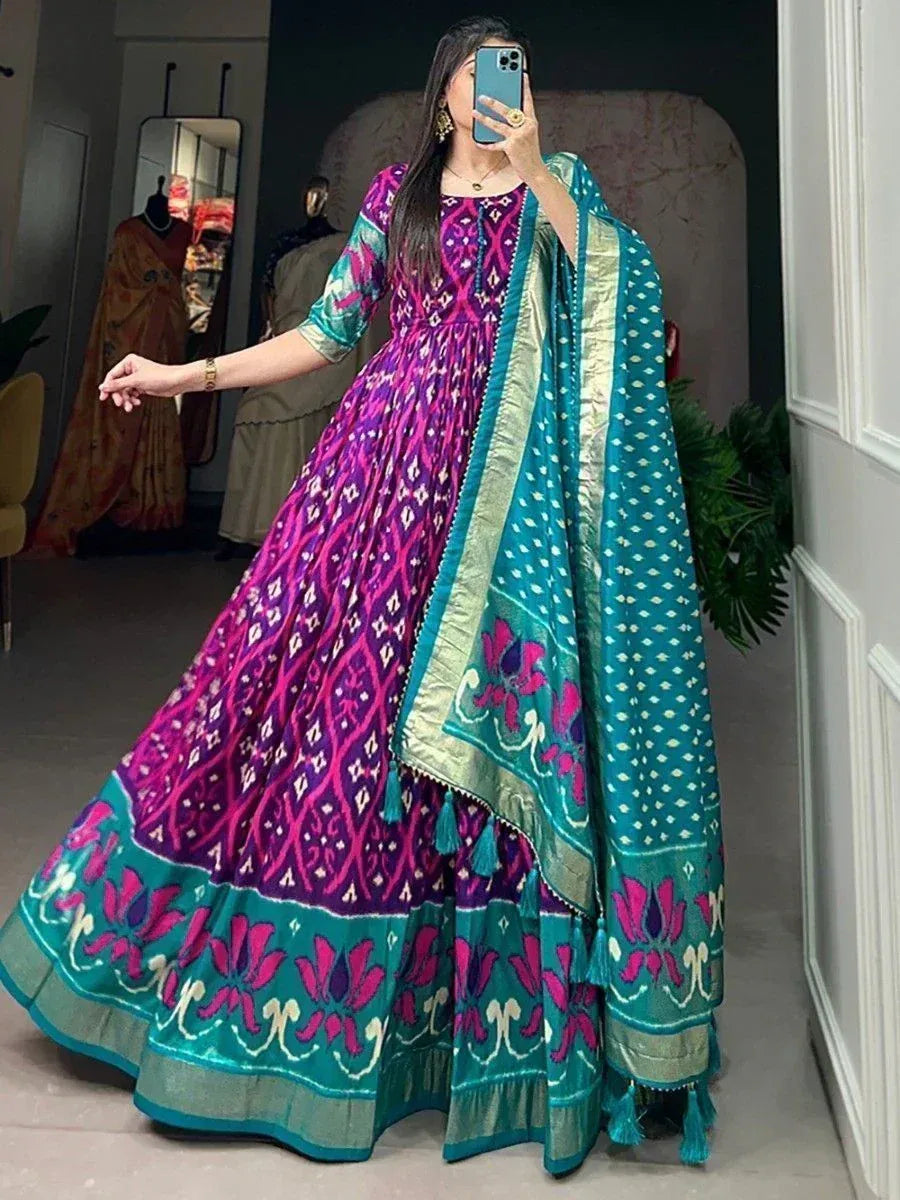 Vibrant purple and teal ethnic anarkali gown with floral print and matching dupatta, perfect for Indian occasions.