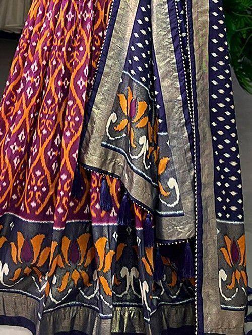 Vibrant ikat print lehenga choli with floral motifs and tassels, perfect for ethnic occasions