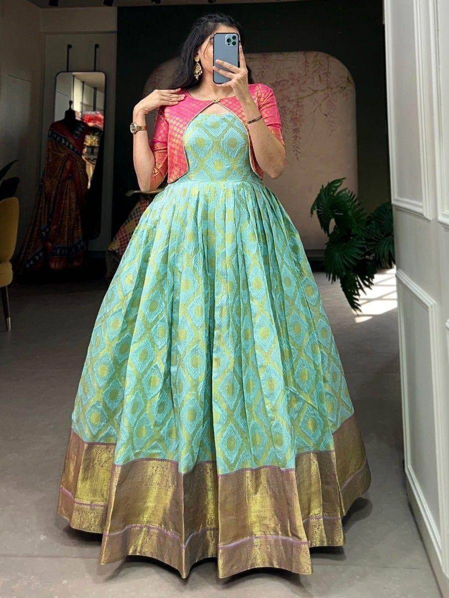Mint green ethnic gown with gold border and pink jacket, perfect for Indian weddings or festive occasions