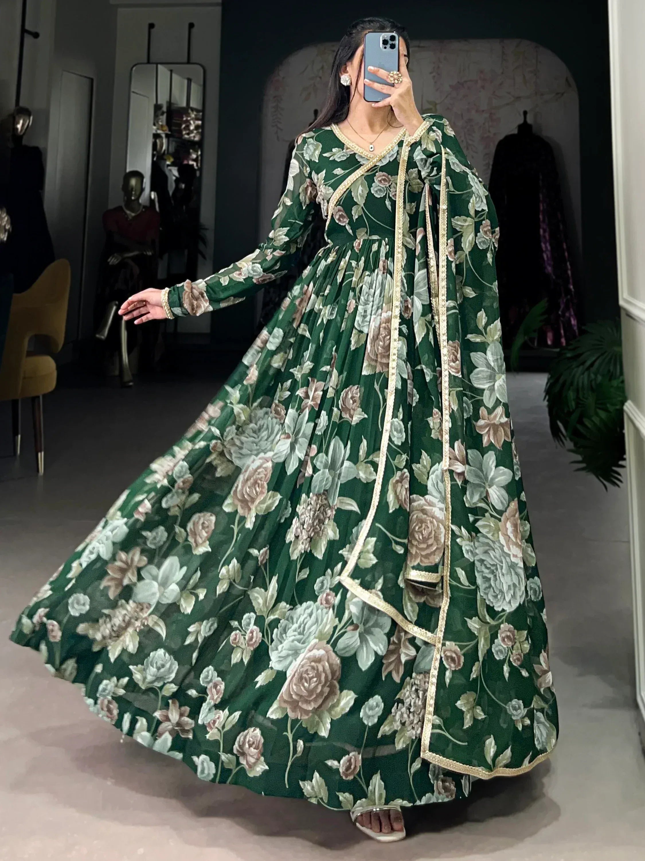 Woman wearing green floral ethnic gown with gold trim in a modern indoor setting