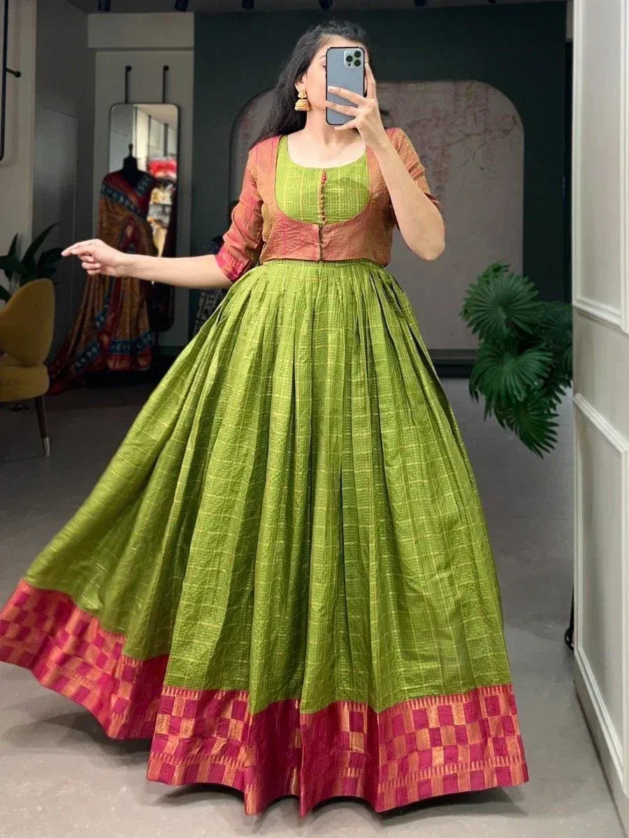 Green and pink ethnic lehenga choli with pleated skirt and contrast border, perfect for Indian occasions