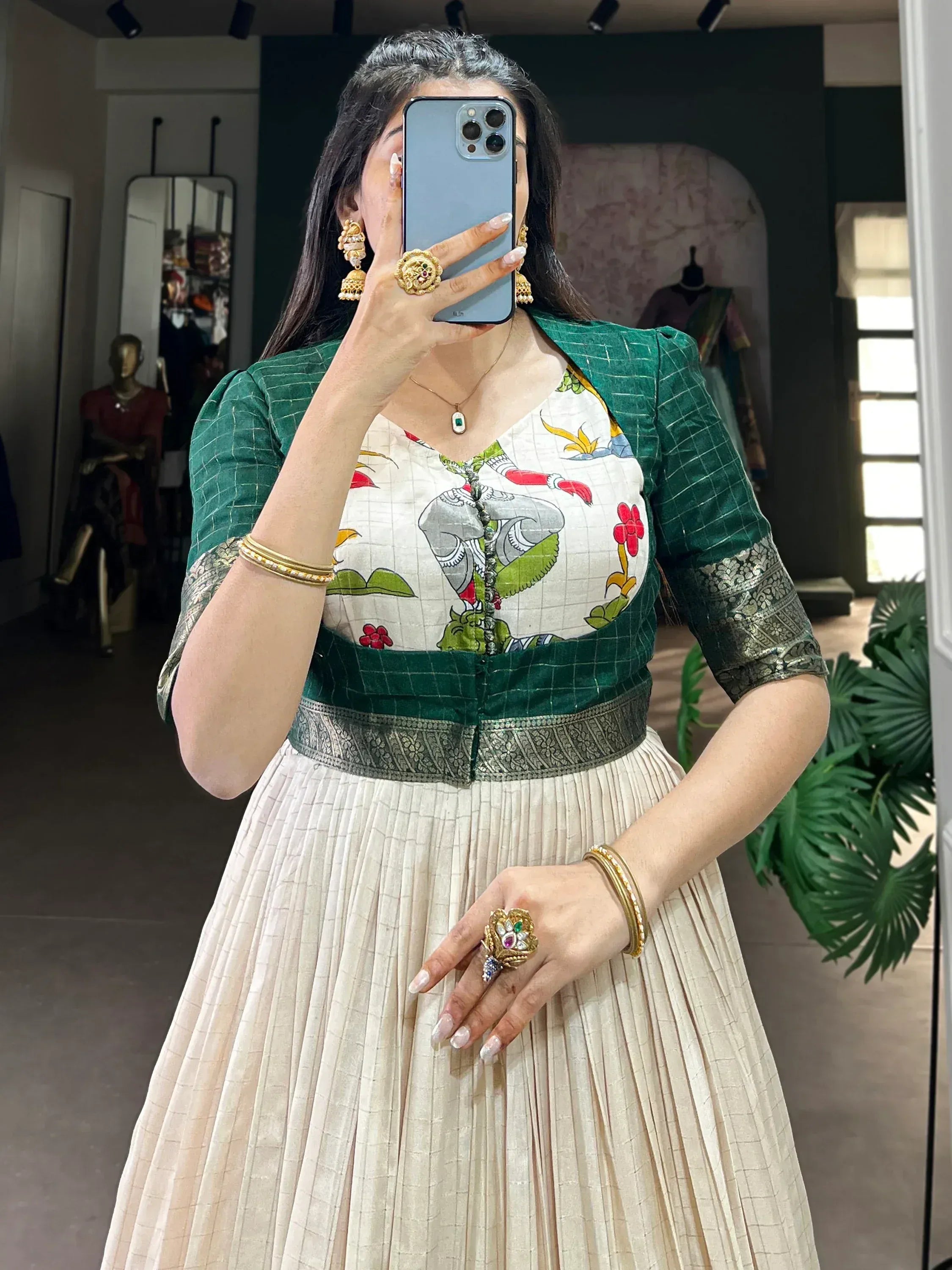 Woman in traditional lehenga choli with green blouse and cream pleated skirt, floral print