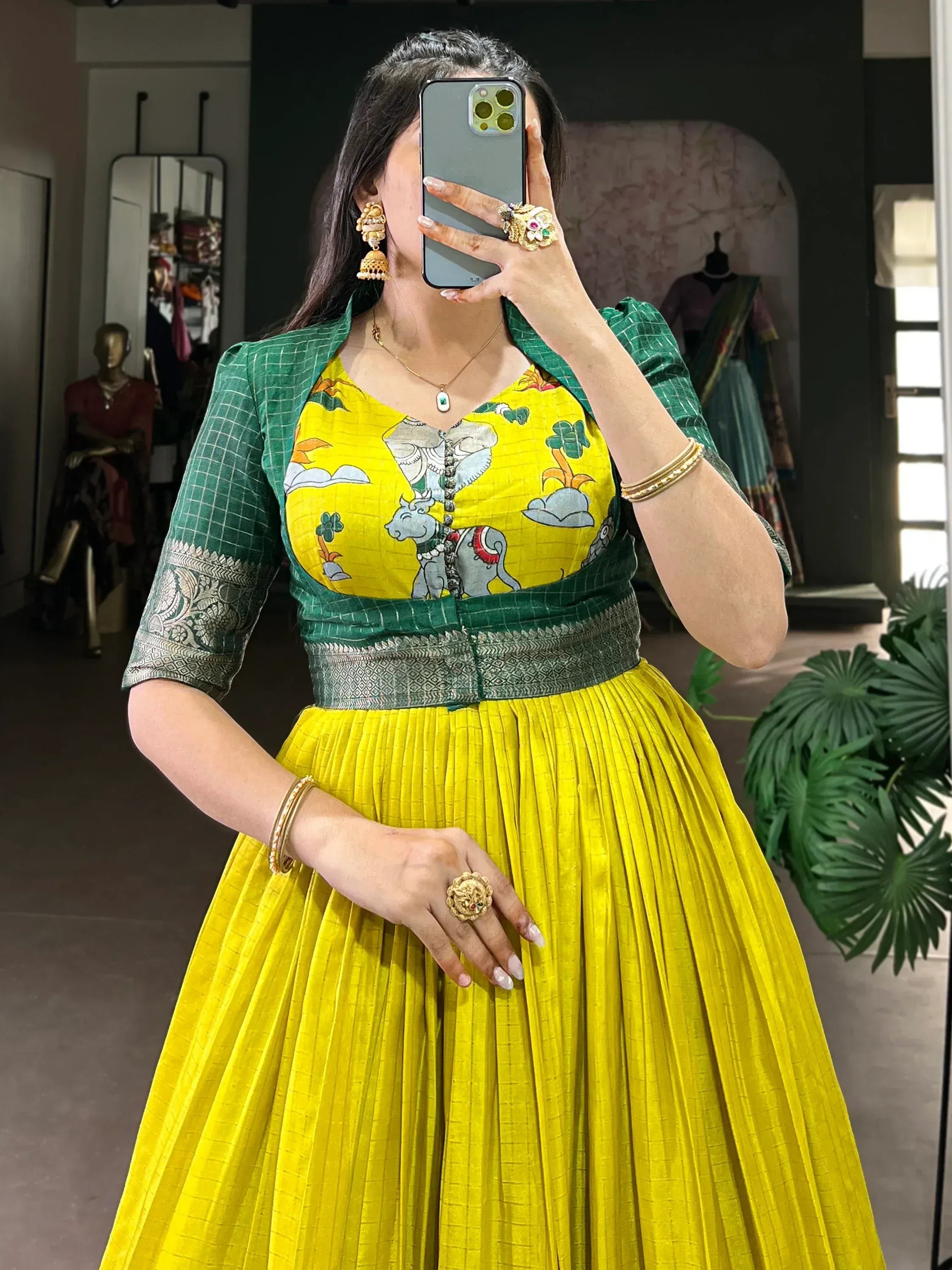 Vibrant yellow pleated skirt with green printed blouse, traditional Indian ethnic wear, perfect for festive occasions.