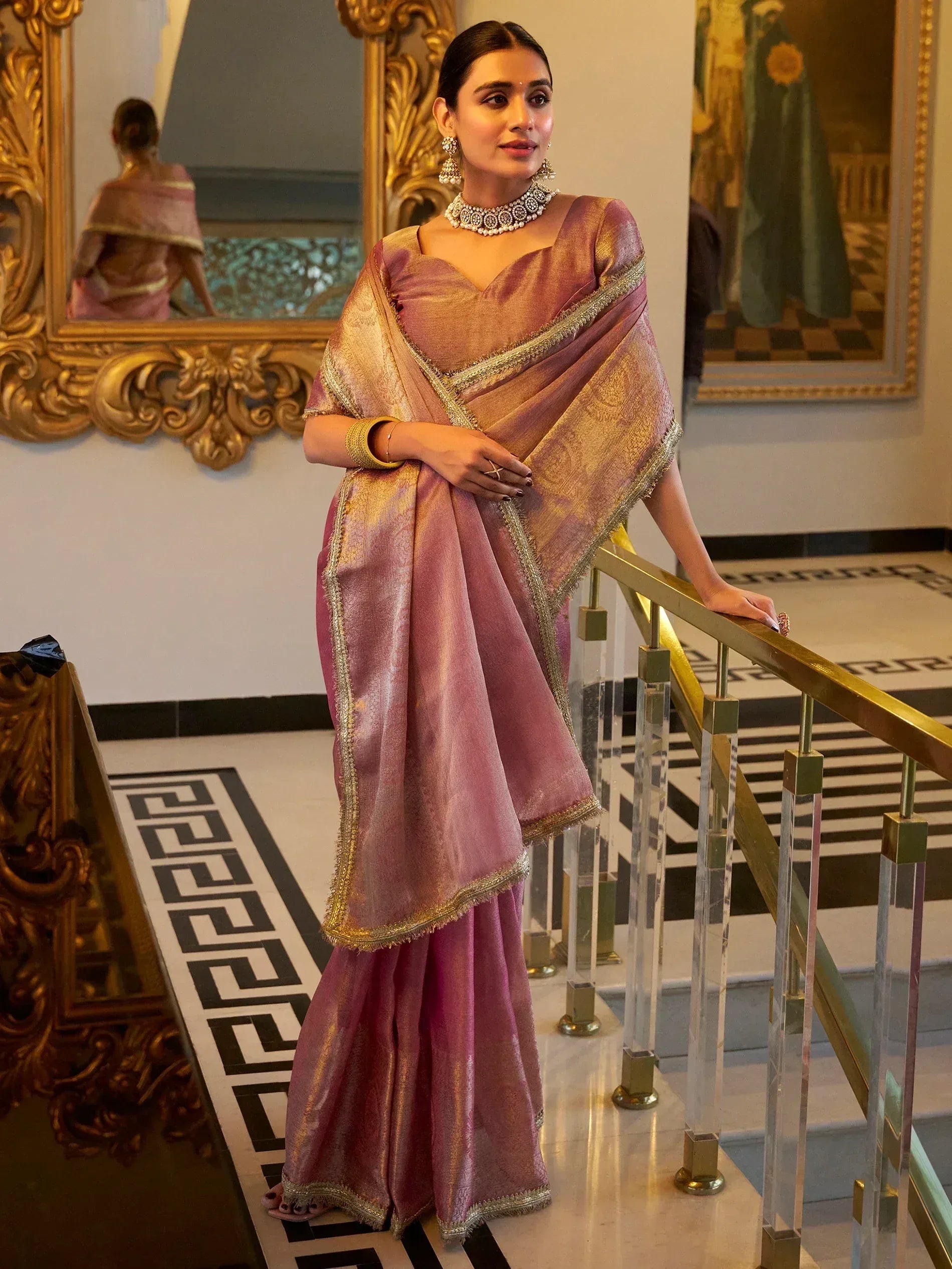 Elegant pink and gold saree with intricate border, styled for festive occasions