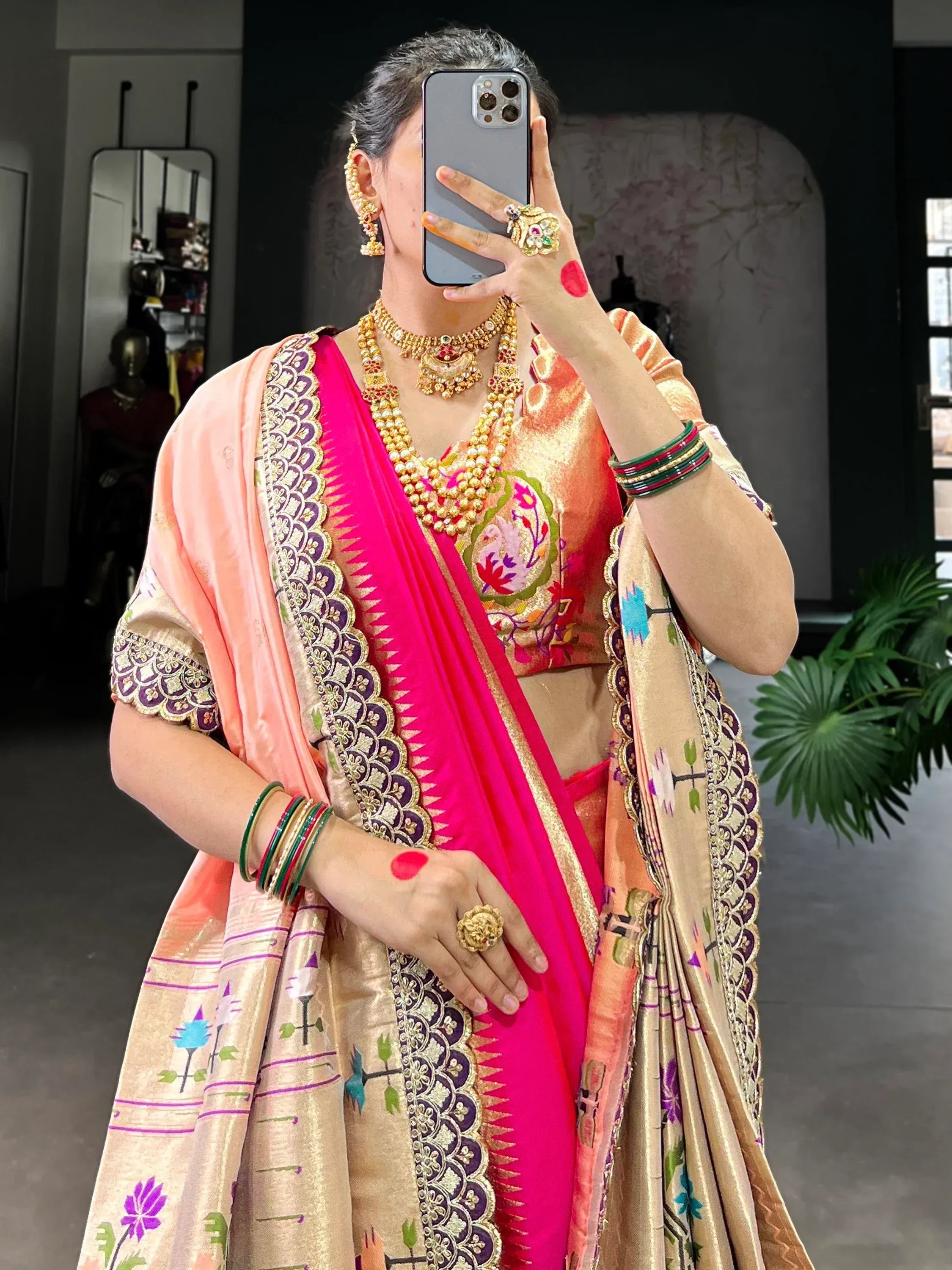 Elegant Indian saree with floral embroidery, gold jewelry, and vibrant pink border for festive occasions.