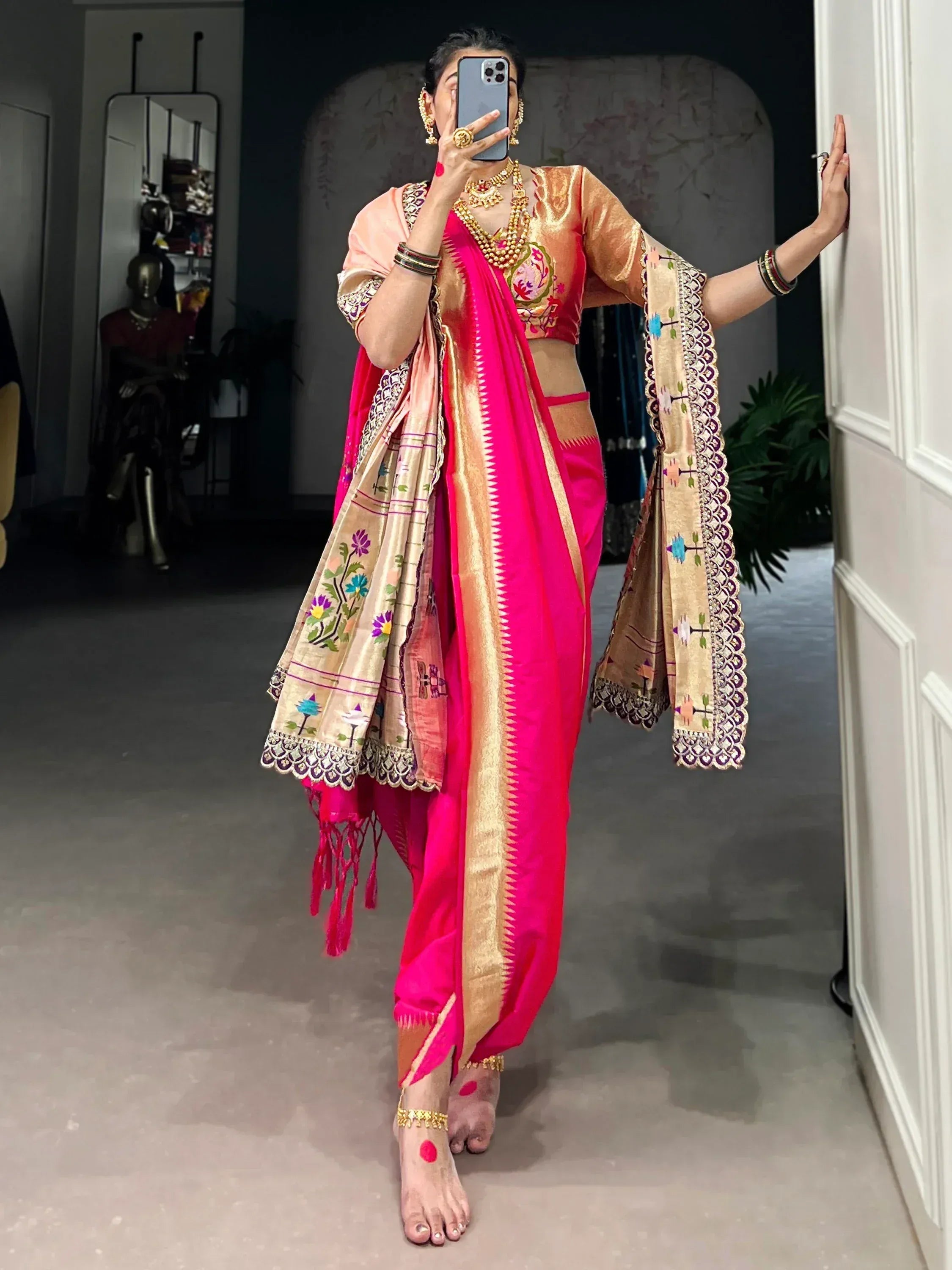 Vibrant pink saree with gold border and floral embroidery, paired with a designer blouse and traditional jewelry.