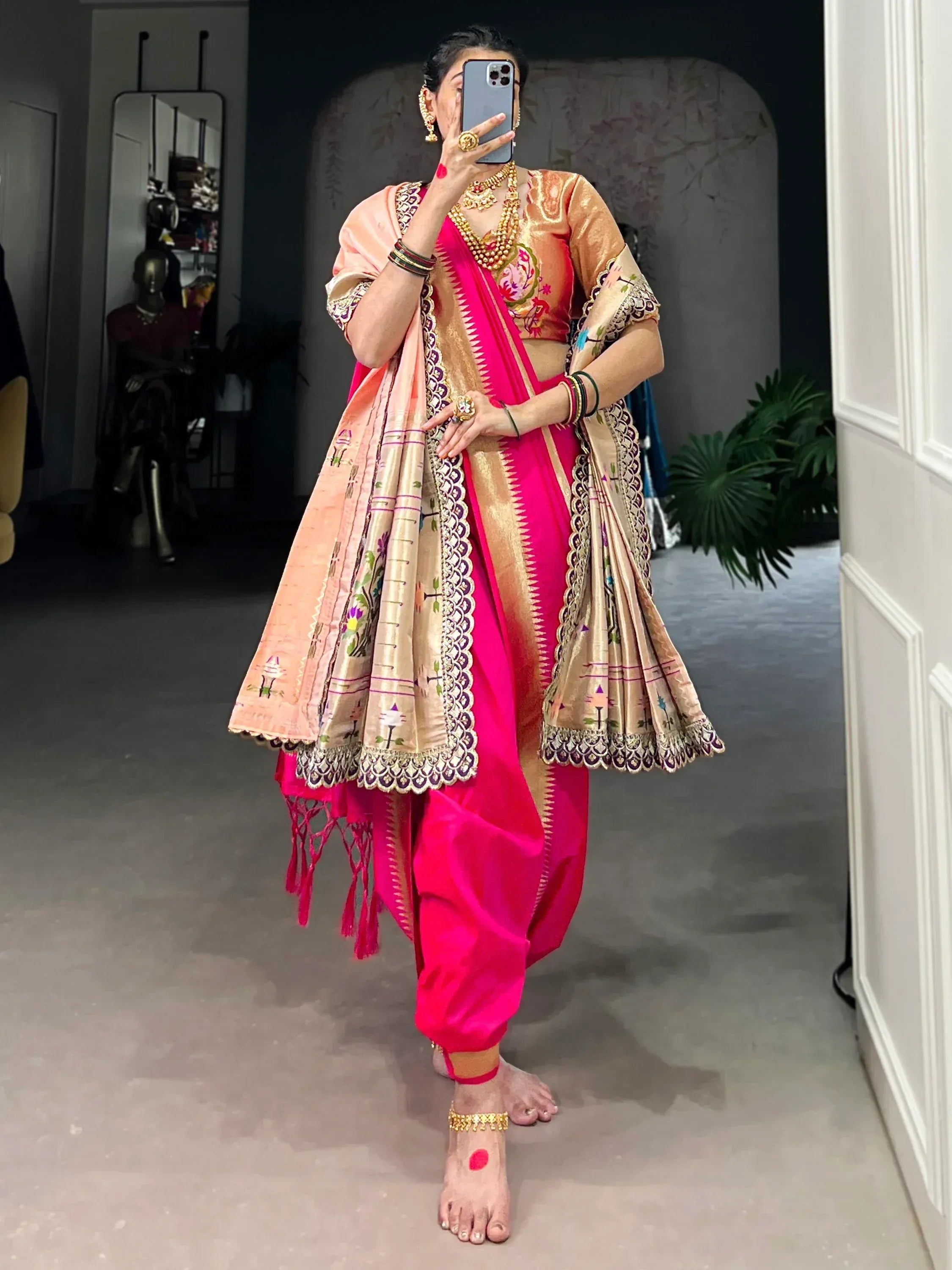 Vibrant pink and gold Indian ethnic dhoti saree with intricate embroidery and traditional jewelry