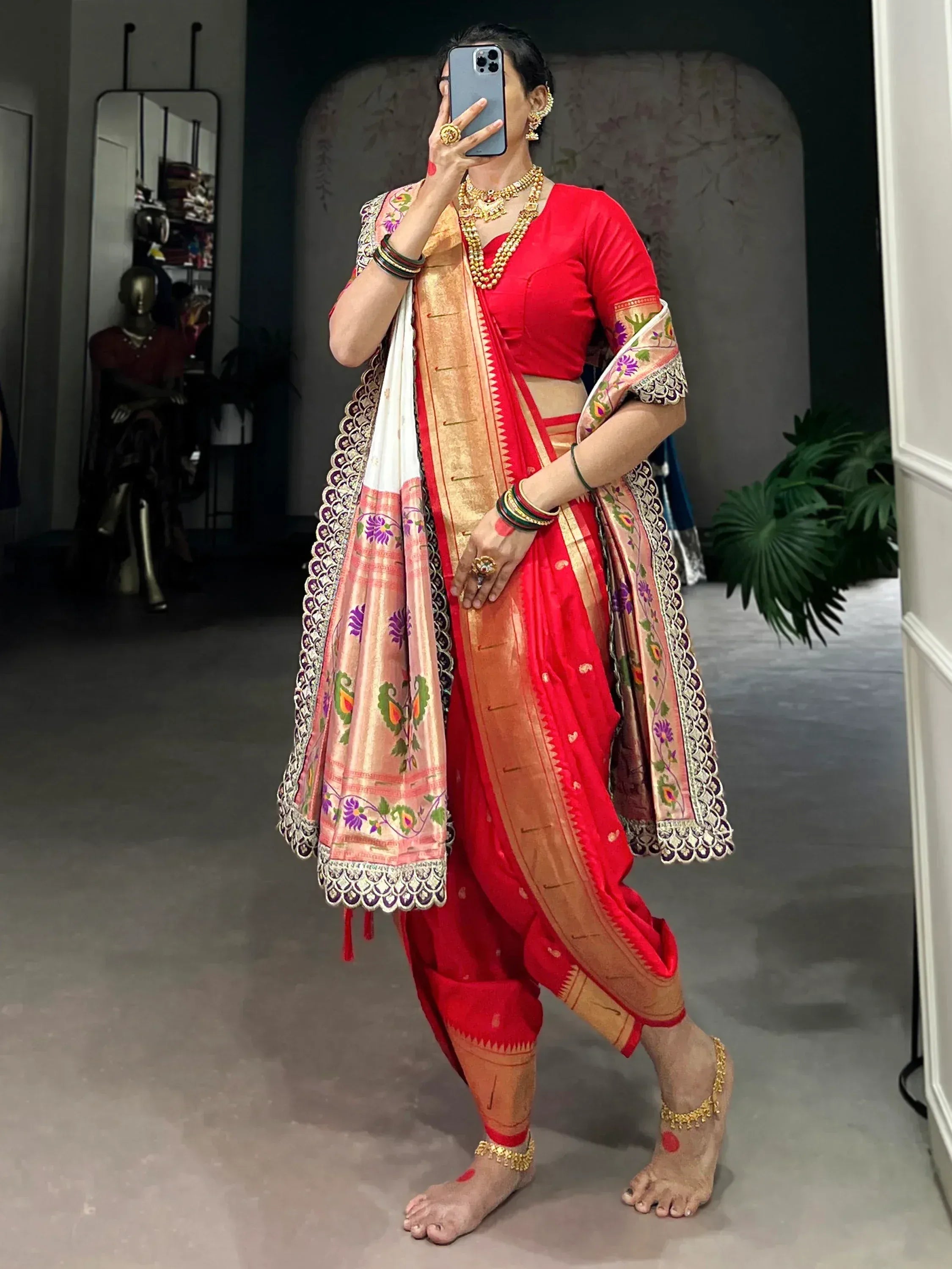 Red ethnic dhoti saree with floral dupatta, perfect for Indian celebrations and weddings.