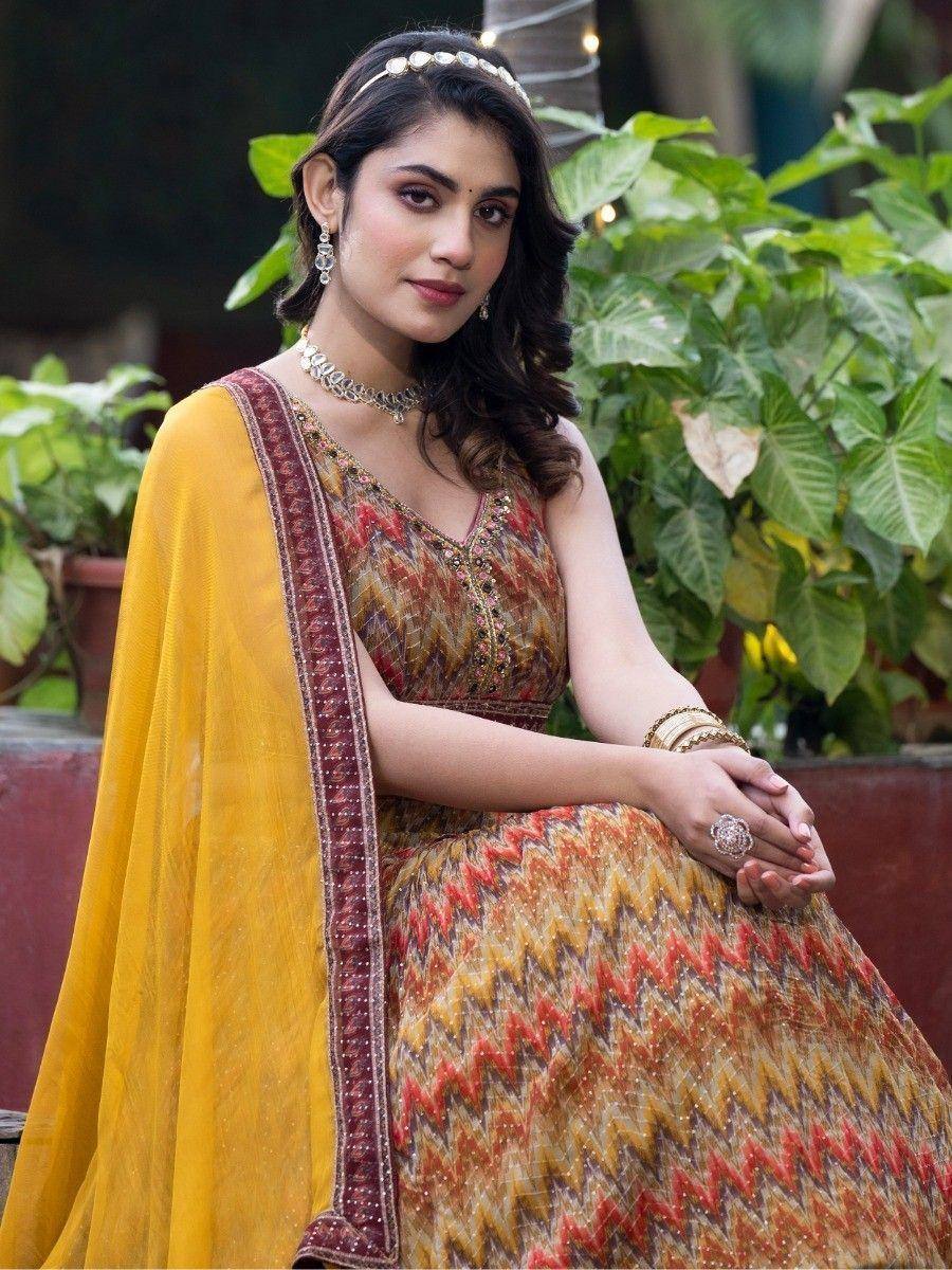 Woman in ethnic Indian lehenga choli with yellow dupatta, floral embroidery, and traditional jewelry