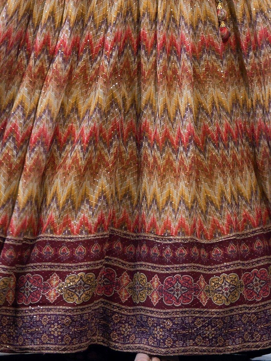 Ethnic lehenga skirt with zigzag print, sequins, and floral border in red, gold, and maroon tones