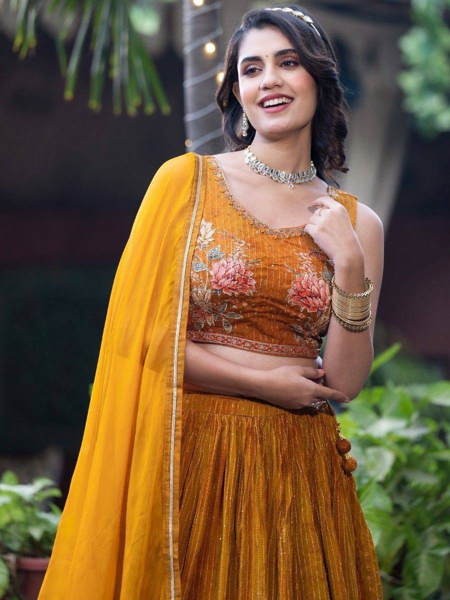Woman in mustard yellow floral embroidered lehenga choli with dupatta, perfect for Indian ethnic occasions