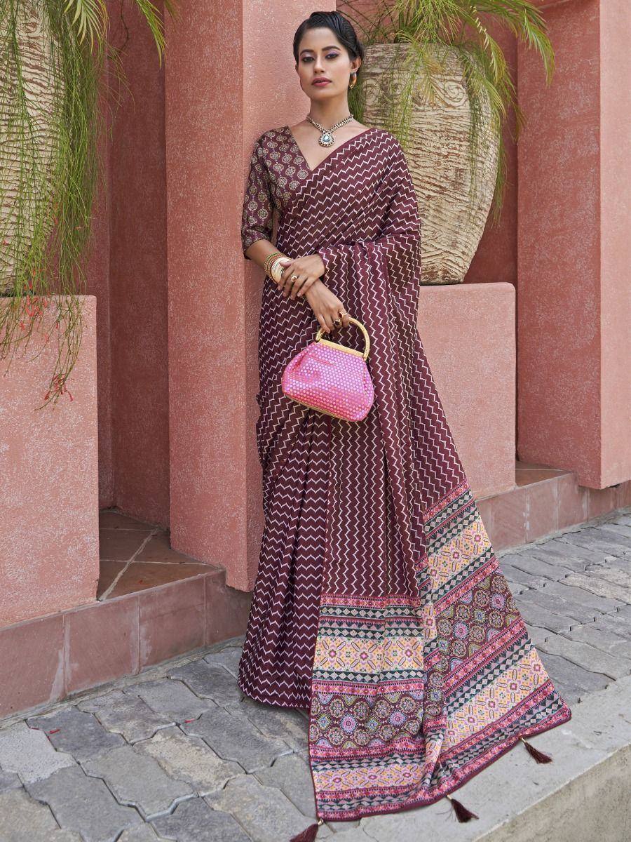 Maroon printed saree with geometric border, ethnic wear for women, paired with pink handbag