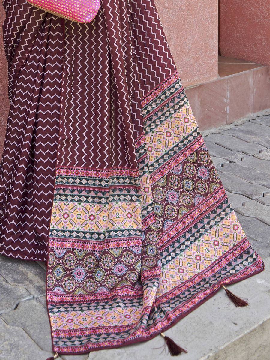 Maroon ethnic lehenga with geometric and floral print, tassels, paired with pink dupatta