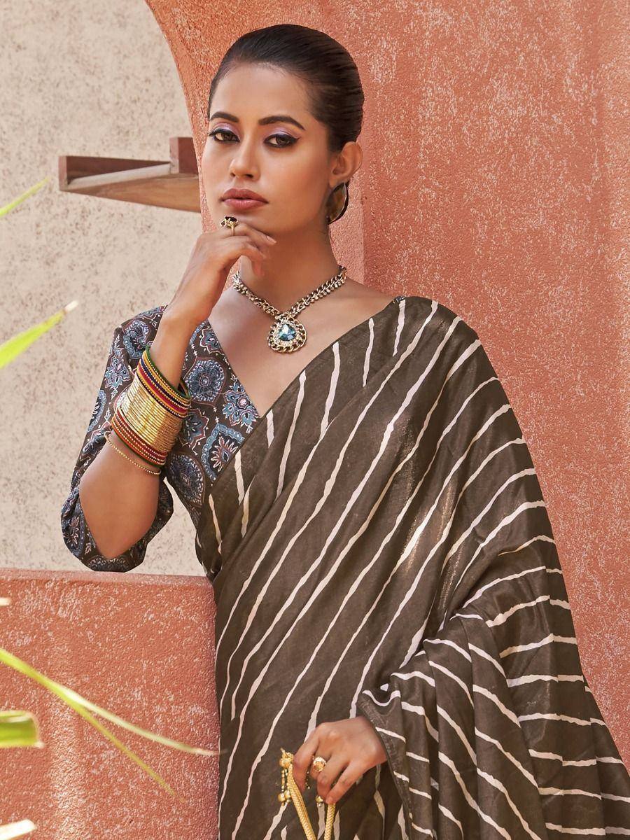 Woman in elegant striped saree with printed blouse, traditional Indian ethnic wear, accessorized with jewelry