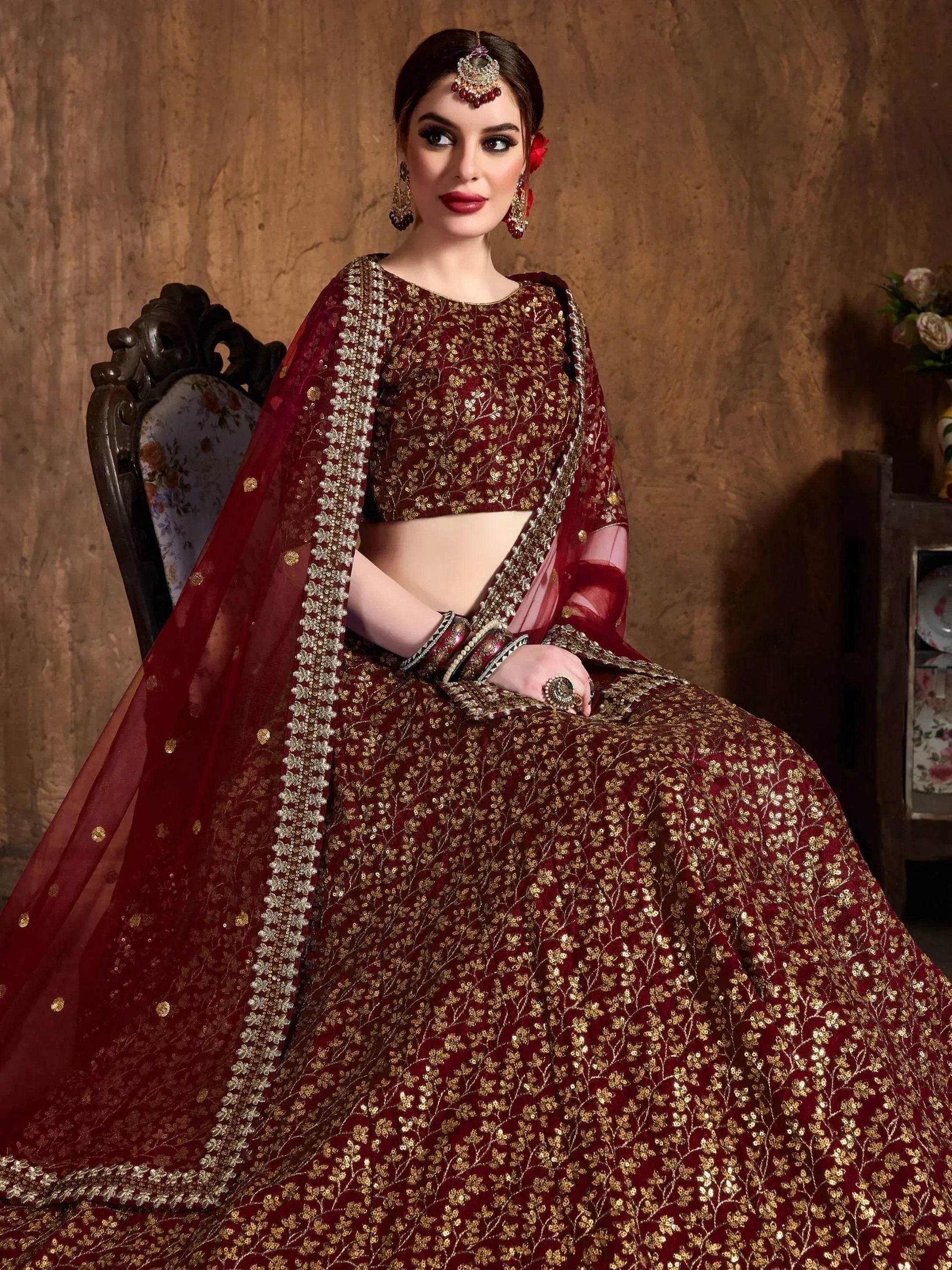 Maroon designer lehenga choli with gold embroidery, perfect for weddings and festive occasions.