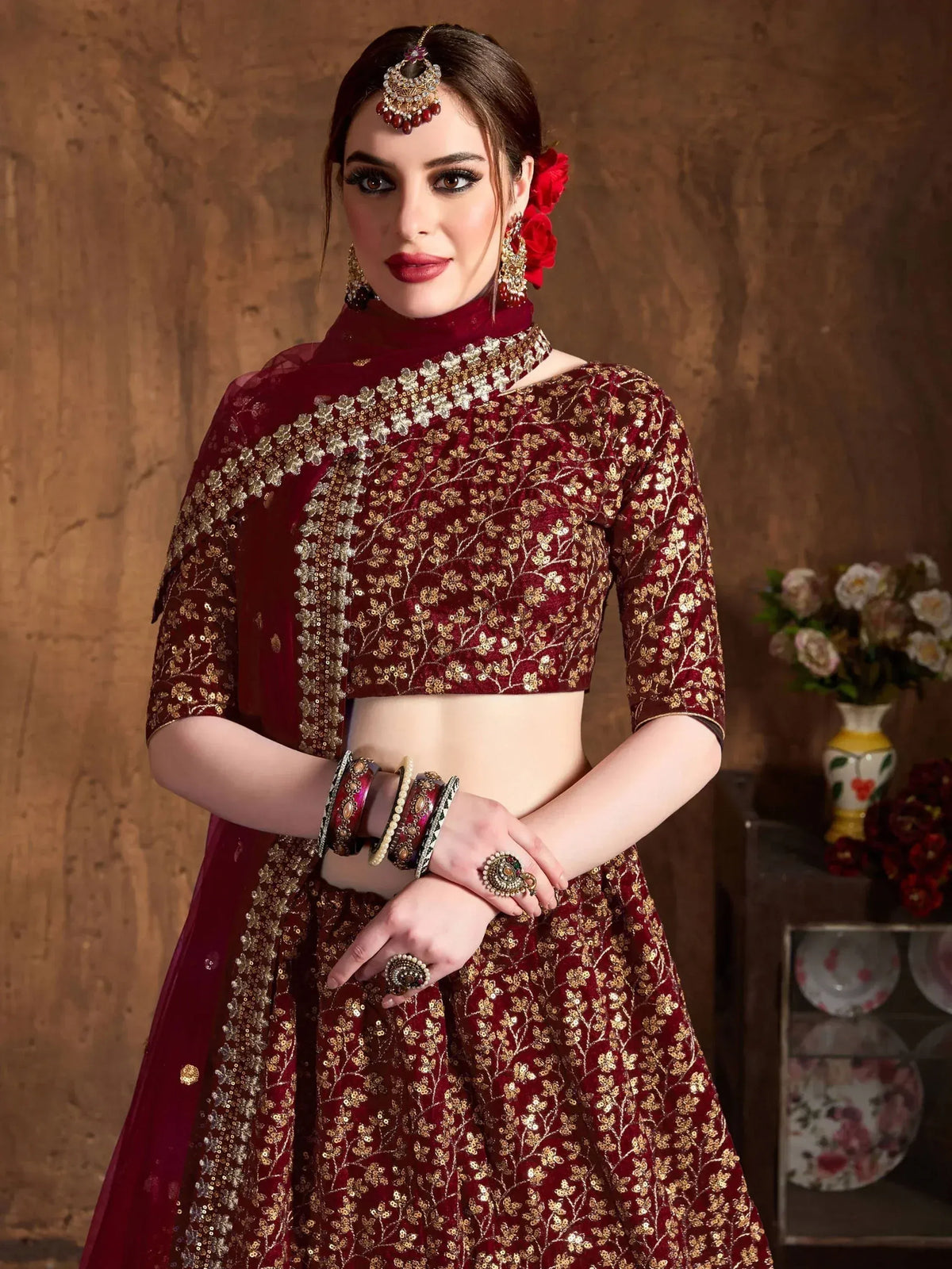 Maroon designer lehenga choli with gold embroidery, perfect for Indian weddings and festive occasions.
