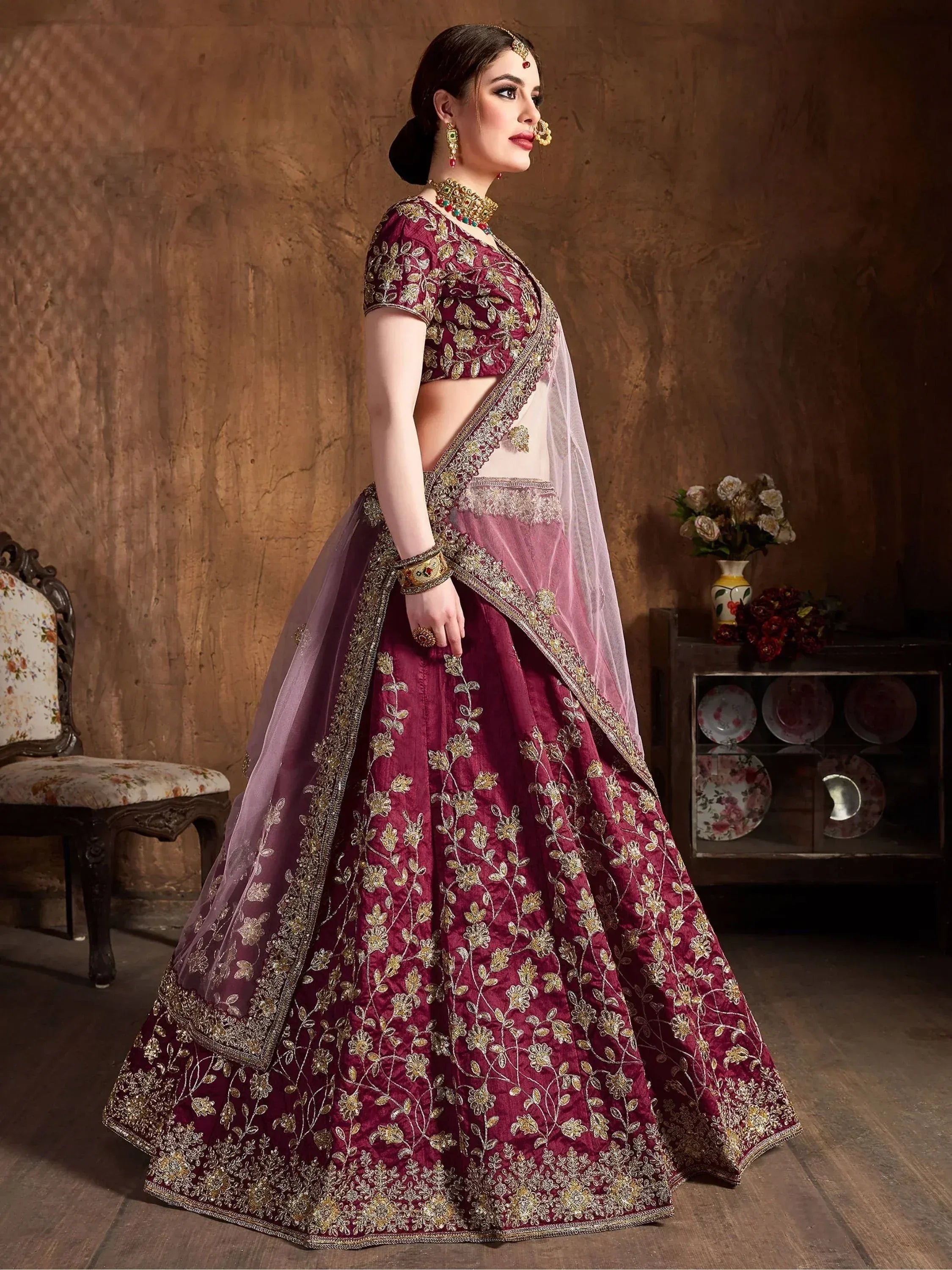 Maroon embroidered lehenga choli with gold floral work, sheer dupatta, perfect for Indian weddings and festive occasions.