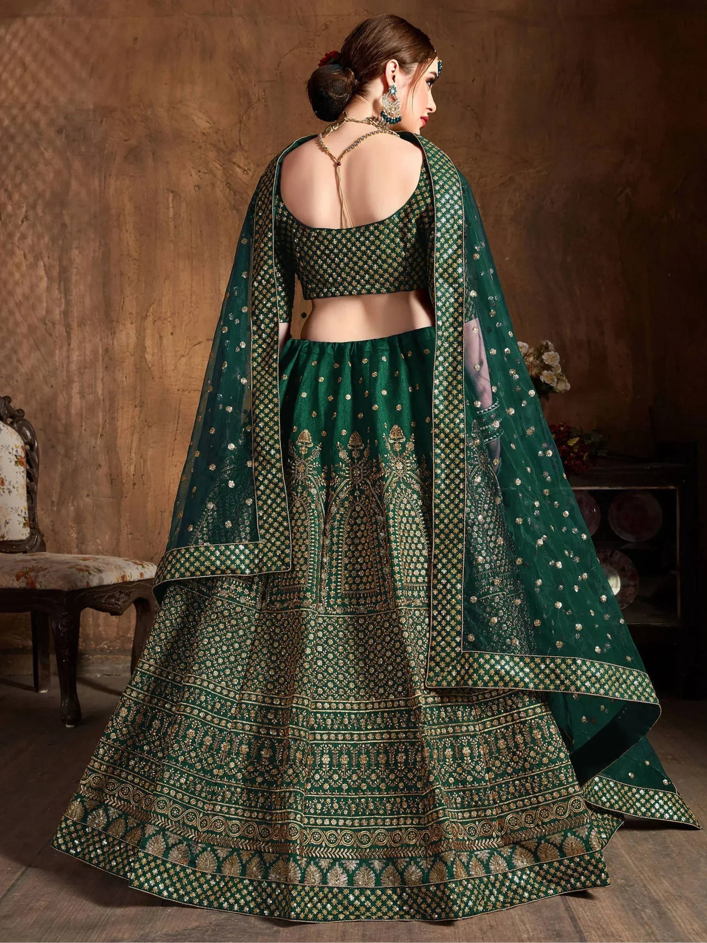 Emerald green designer lehenga choli with gold embroidery and sheer dupatta, back view