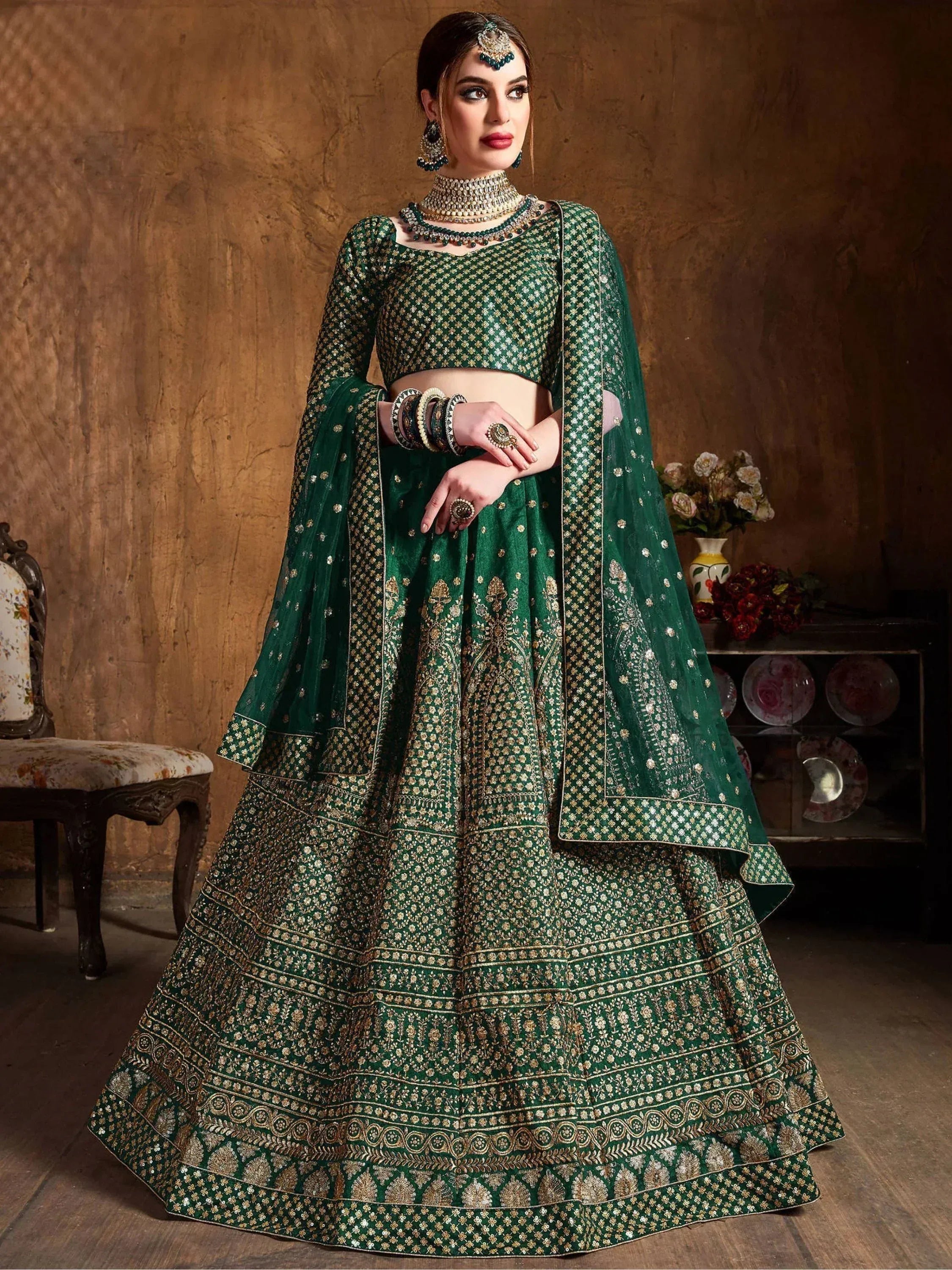 Emerald green designer lehenga choli with gold embroidery, perfect for Indian weddings and festive occasions.