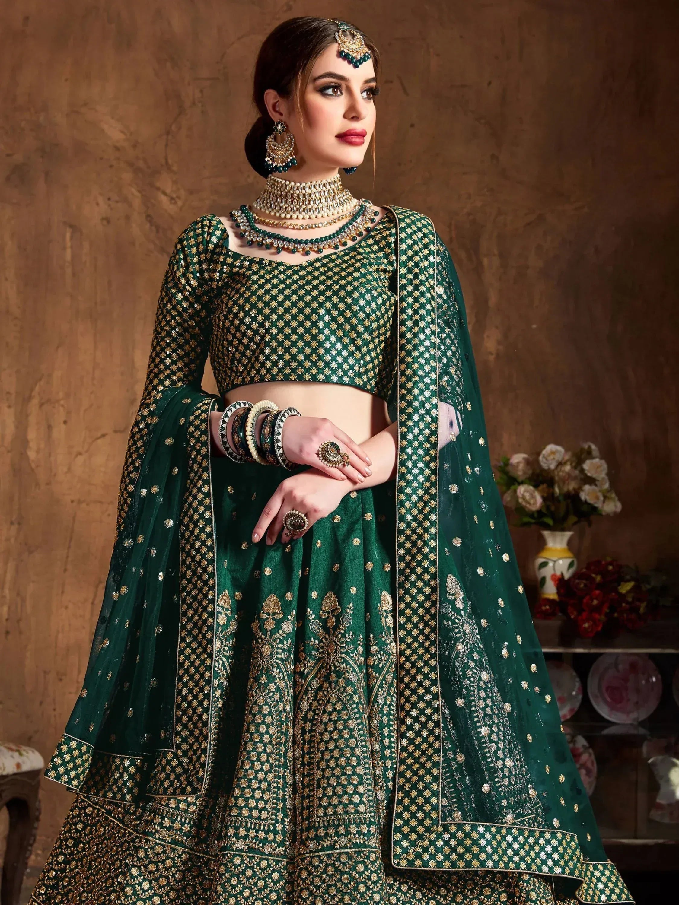 Emerald green designer lehenga choli with gold floral embroidery and matching dupatta, perfect for Indian weddings.