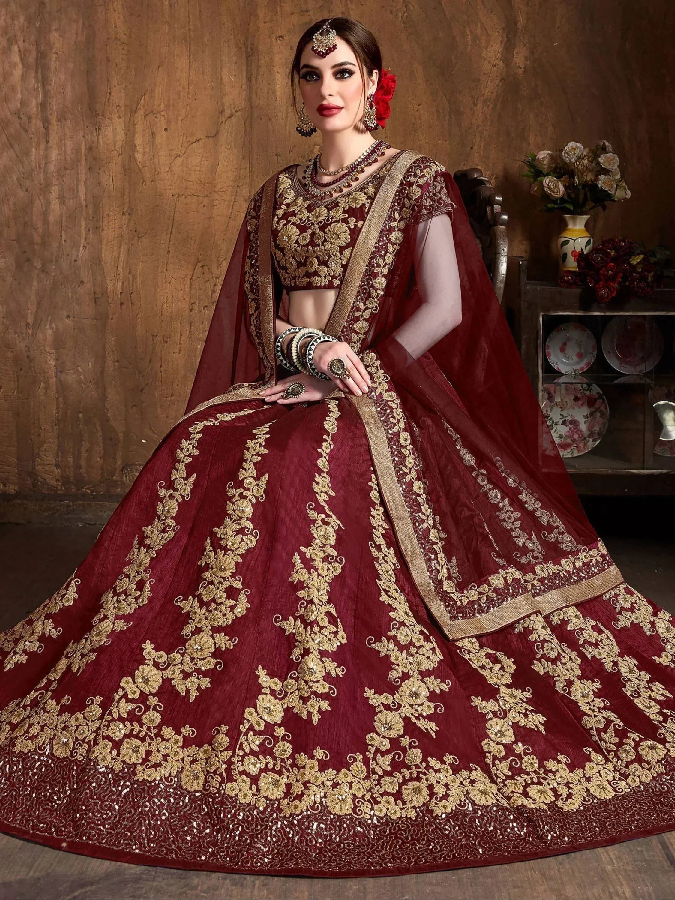 Maroon designer lehenga choli with gold floral embroidery, perfect for Indian weddings and festive occasions.