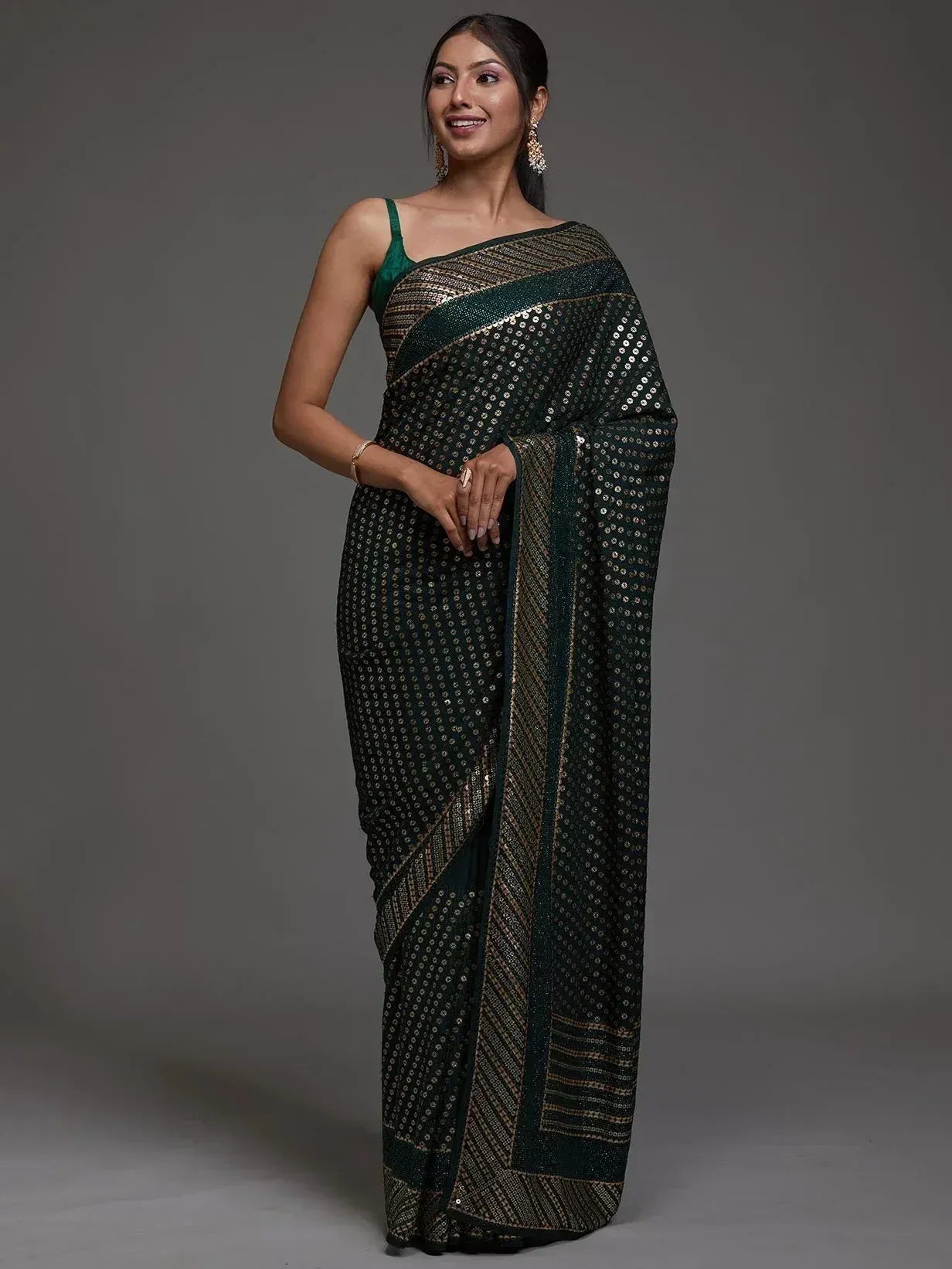 Elegant green saree with sequin detailing and gold border, perfect for ethnic occasions