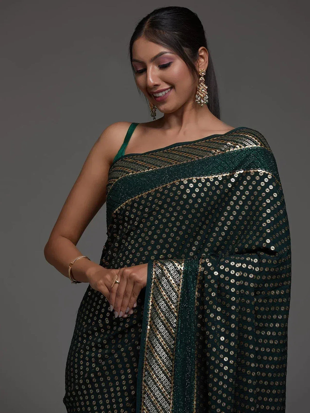 Elegant green saree with gold sequin detailing, perfect for ethnic occasions