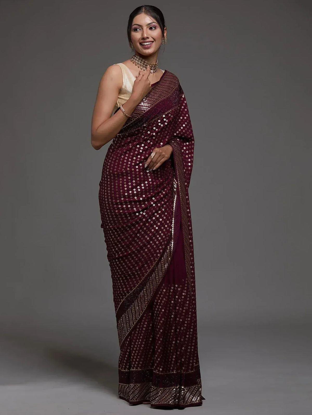 Woman in maroon sequin saree with gold blouse, perfect for Indian ethnic occasions