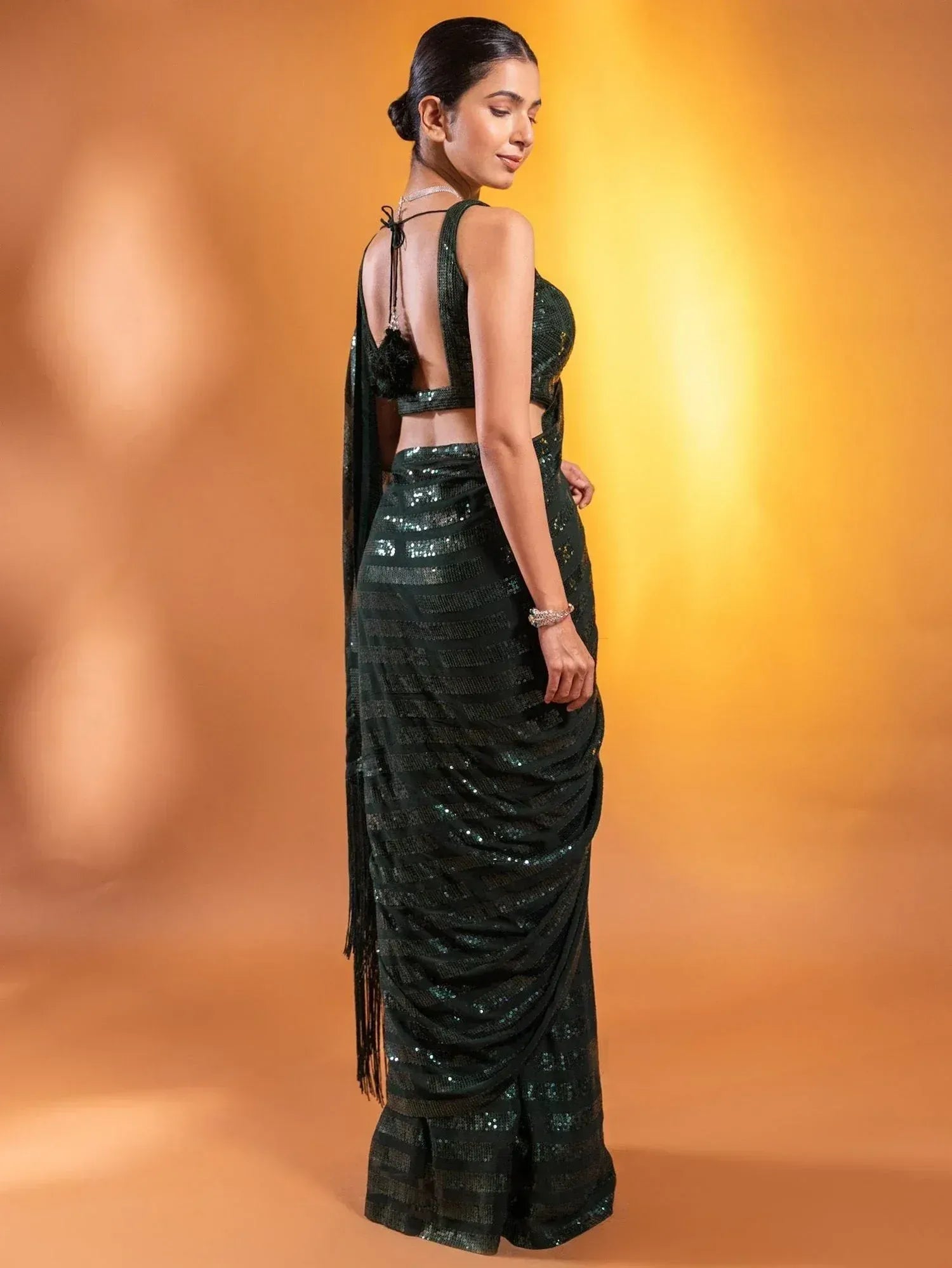 Elegant dark green sequin saree with backless blouse, perfect for Indian ethnic occasions