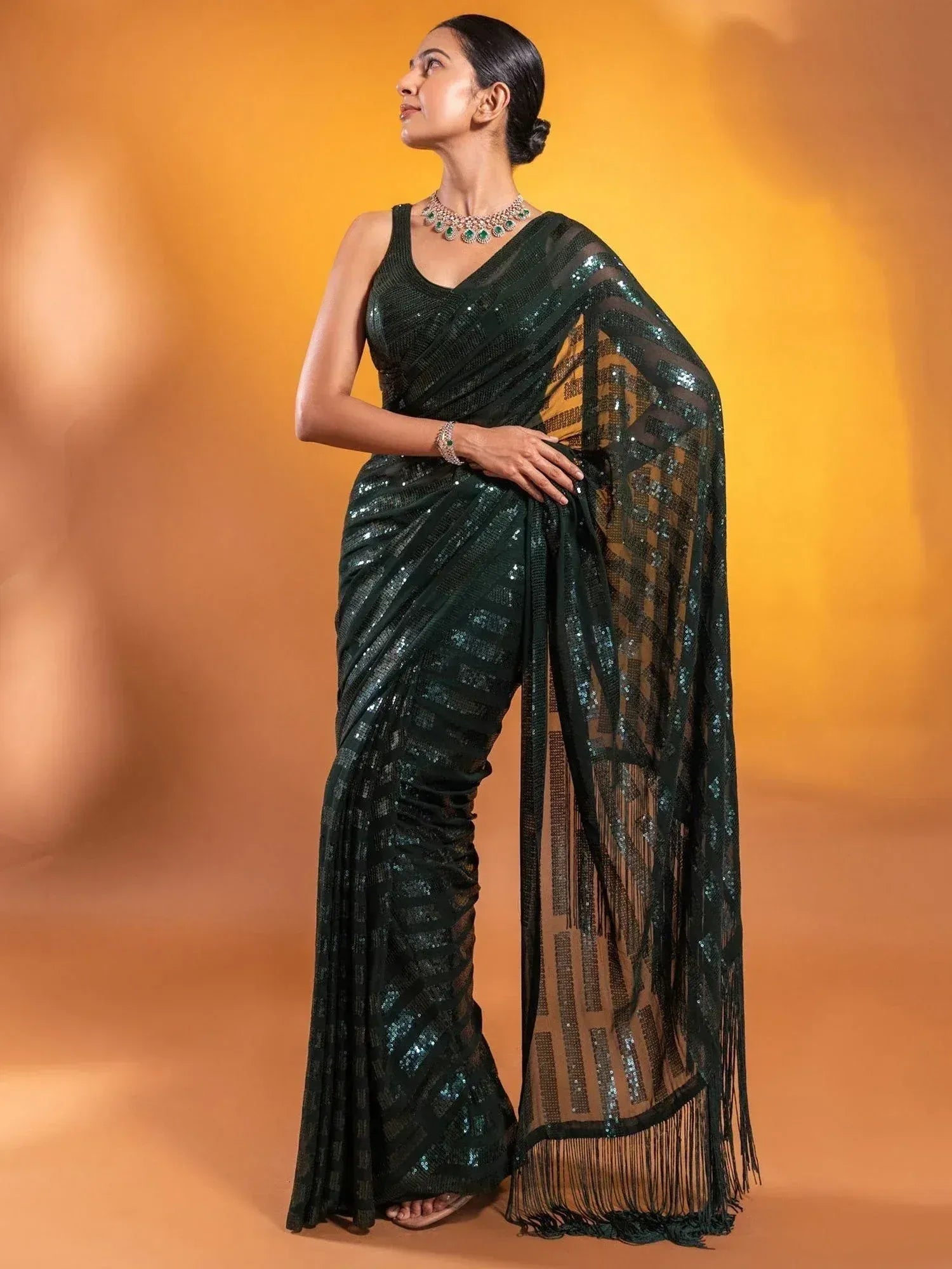 Elegant dark green sequin saree with fringe border, perfect for Indian ethnic wear events.