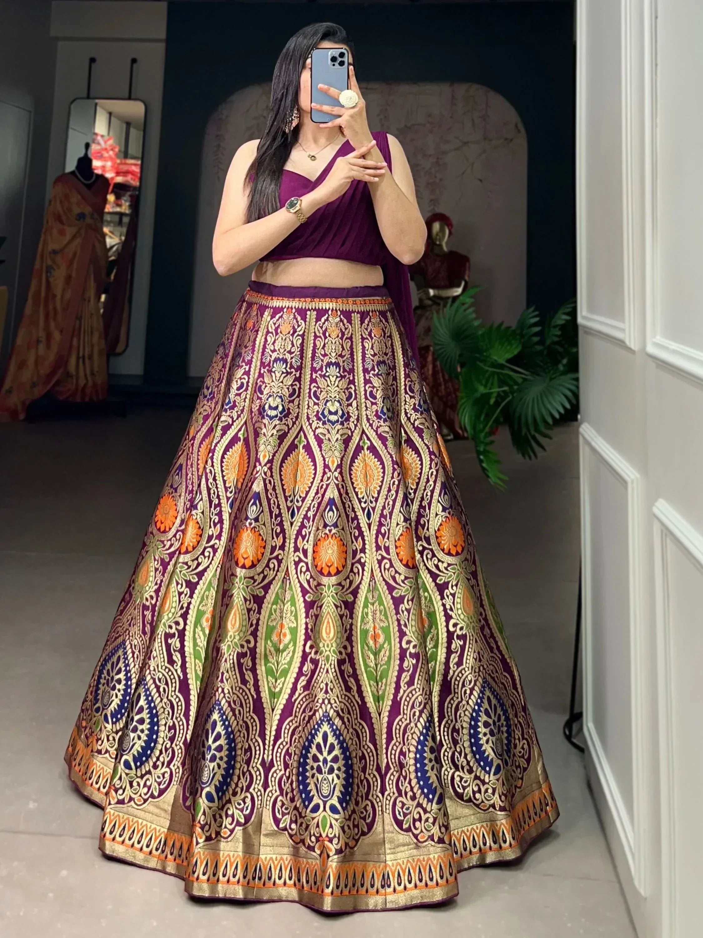Purple designer lehenga choli with intricate gold, orange, and blue floral patterns, perfect for Indian ethnic wear.