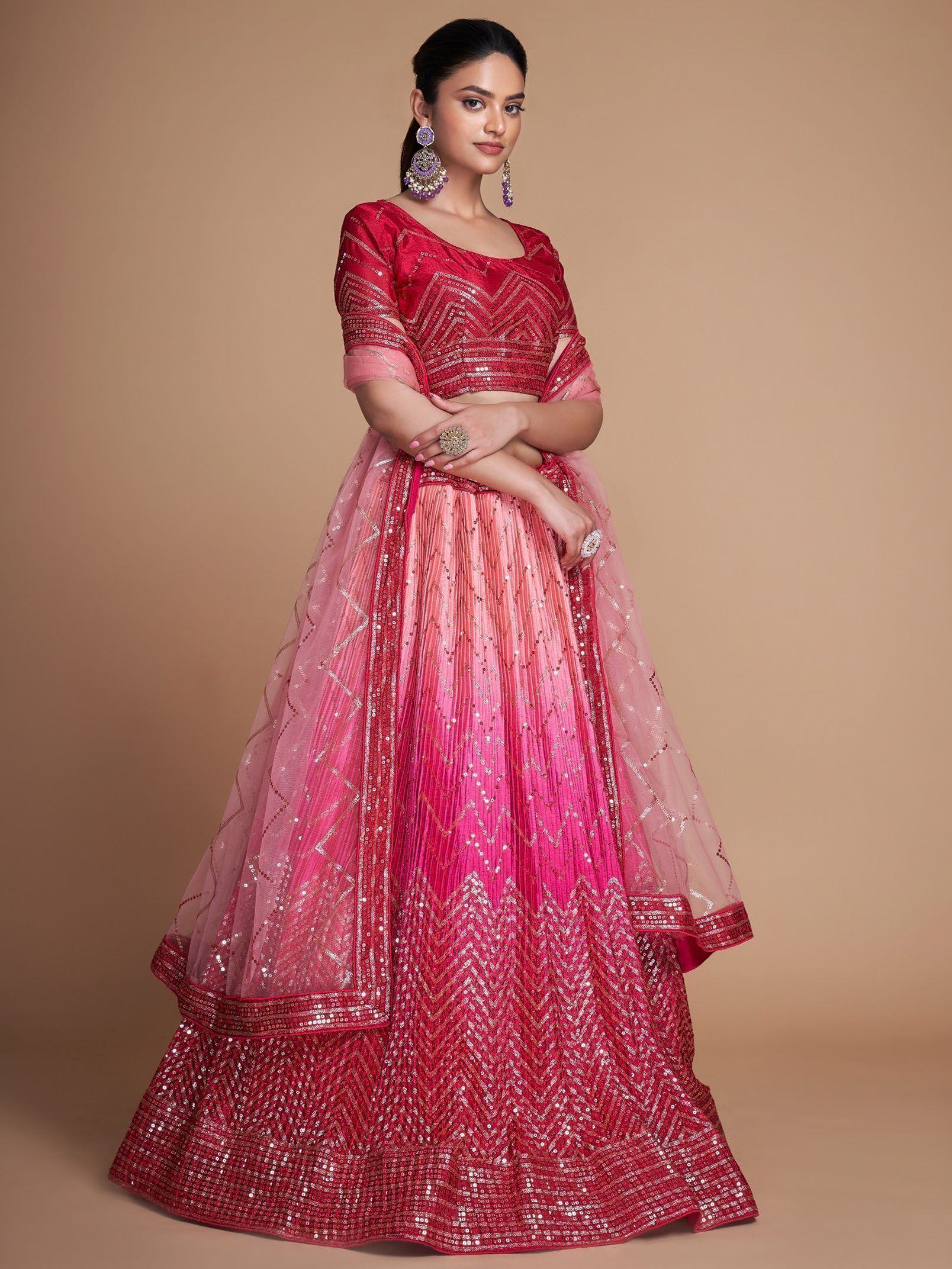Red and pink sequined lehenga choli with geometric embroidery, perfect for Indian weddings and festive occasions.