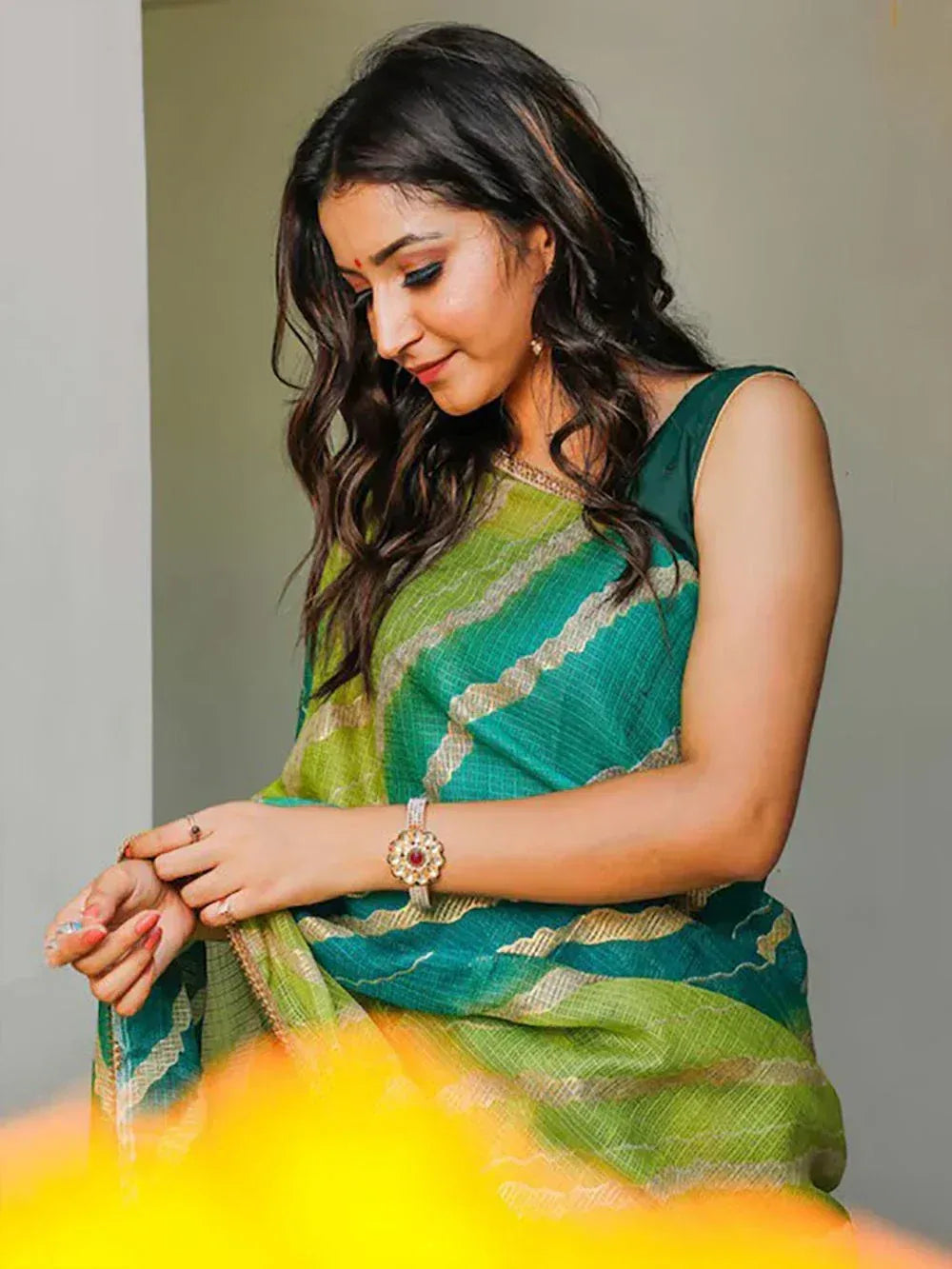 Woman in green and teal striped saree with gold border, elegant ethnic wear for festive occasions