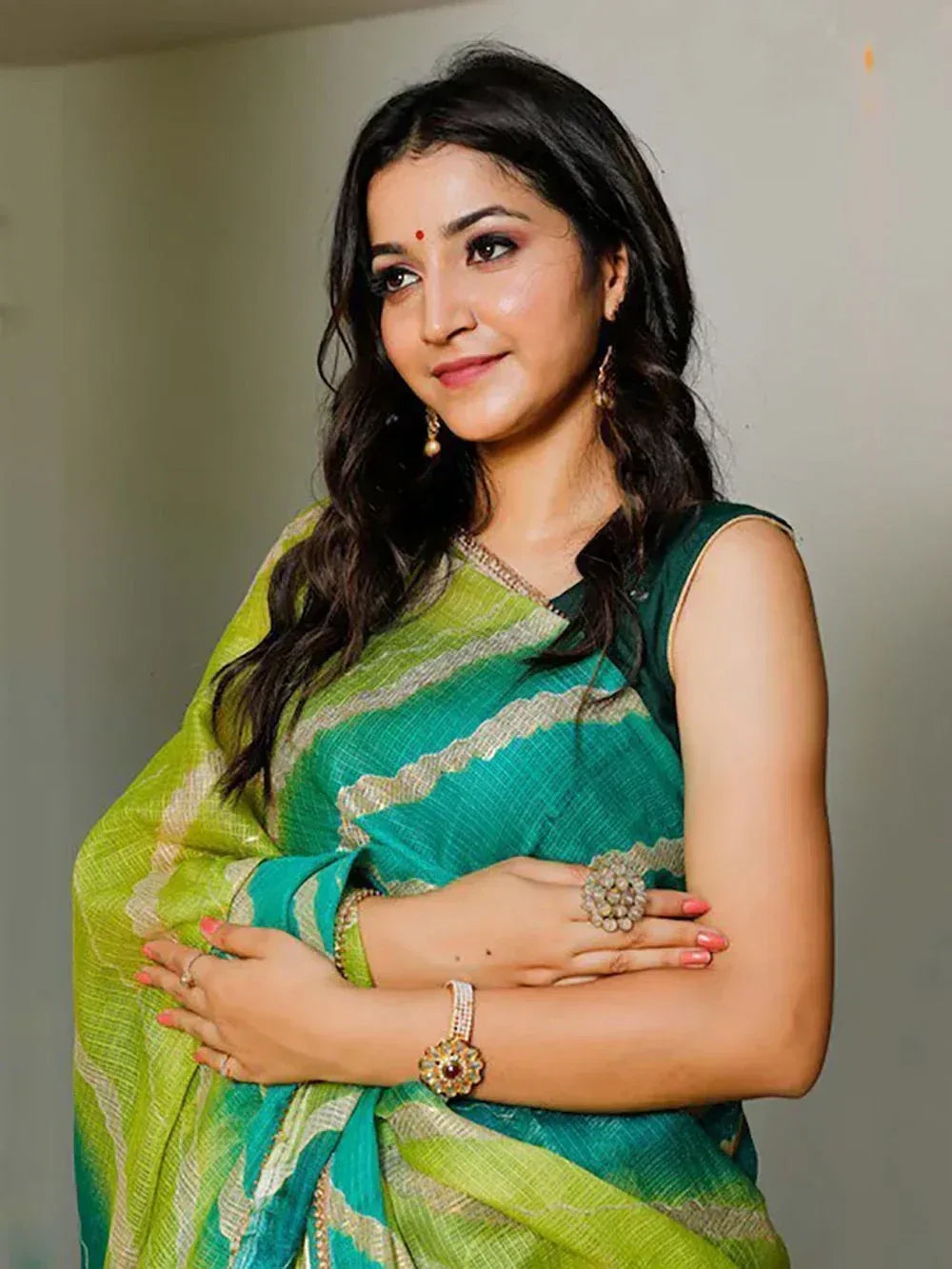 Woman in green and lime striped saree with gold embroidery, ethnic Indian wear