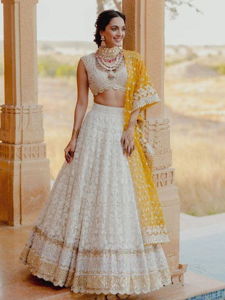 Elegant white embroidered lehenga choli with yellow dupatta, perfect for Indian weddings and festive occasions