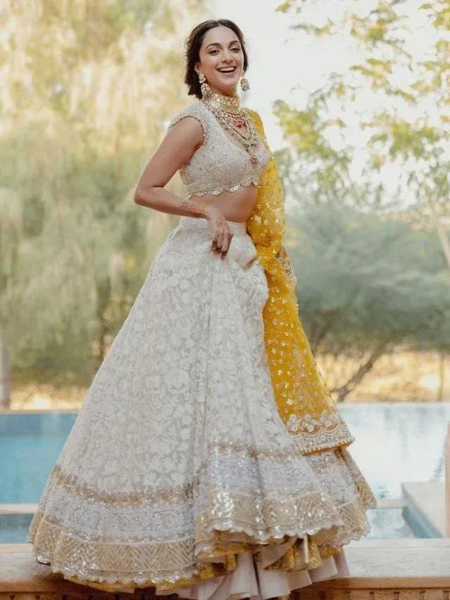 Elegant white and gold embroidered lehenga choli with yellow dupatta, perfect for Indian weddings and festive occasions.