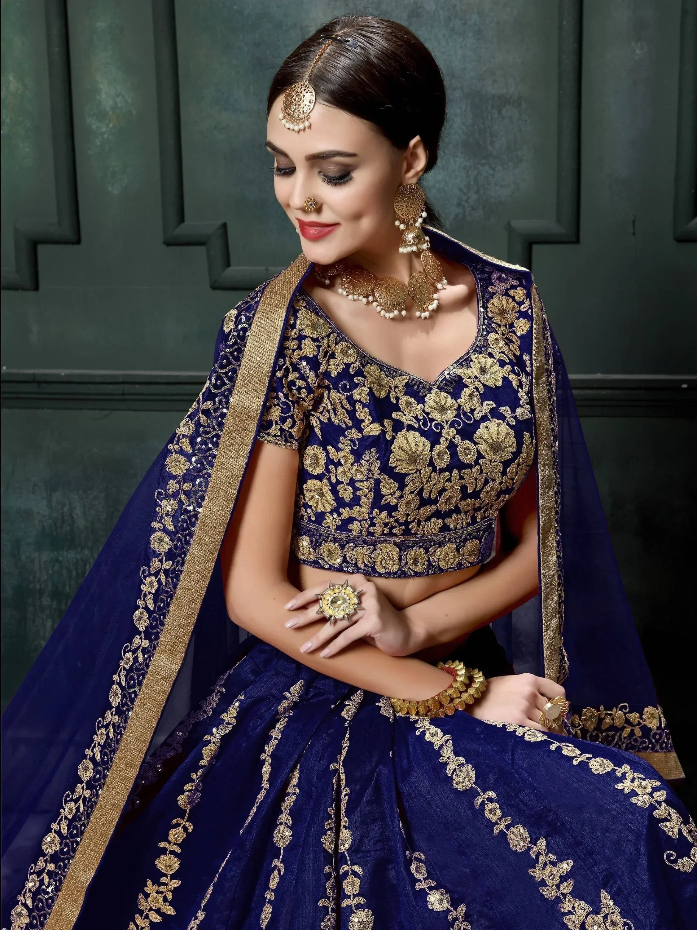 Royal blue lehenga choli with gold floral embroidery, perfect for Indian weddings and festive occasions.