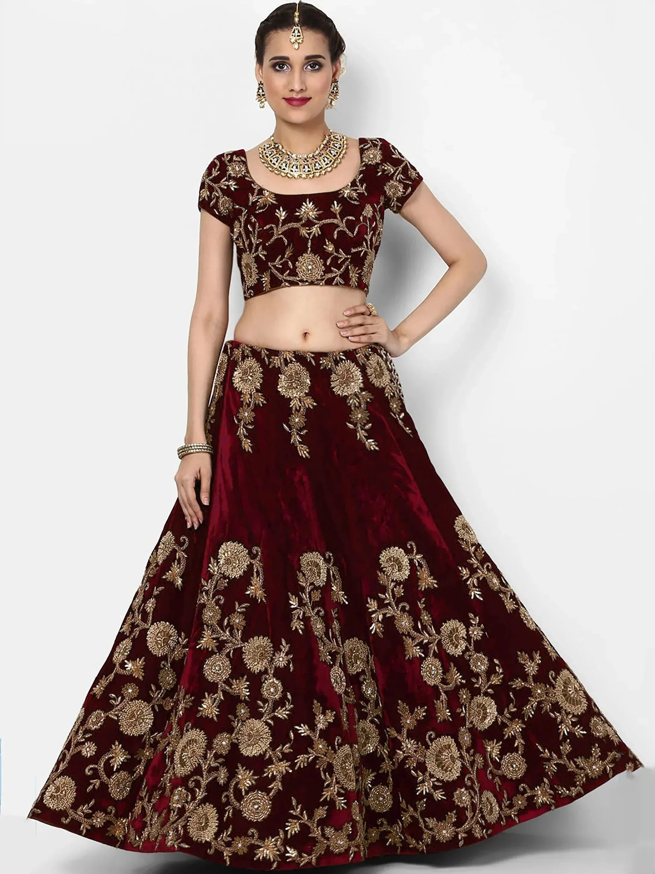 Maroon velvet lehenga choli with gold floral embroidery, perfect for Indian weddings and festive occasions.