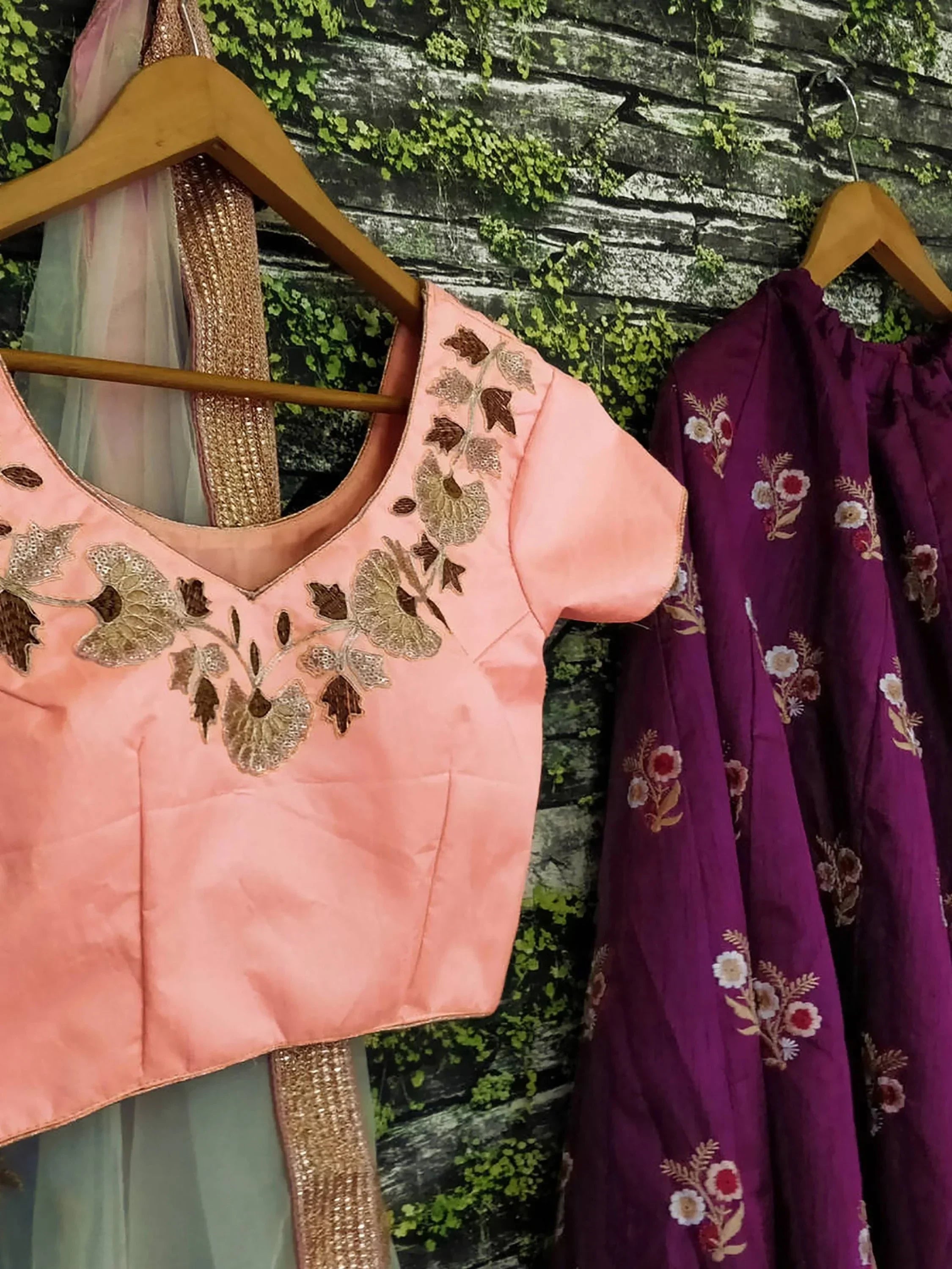 Pink embroidered lehenga choli top with floral design, paired with purple floral skirt, ethnic wear