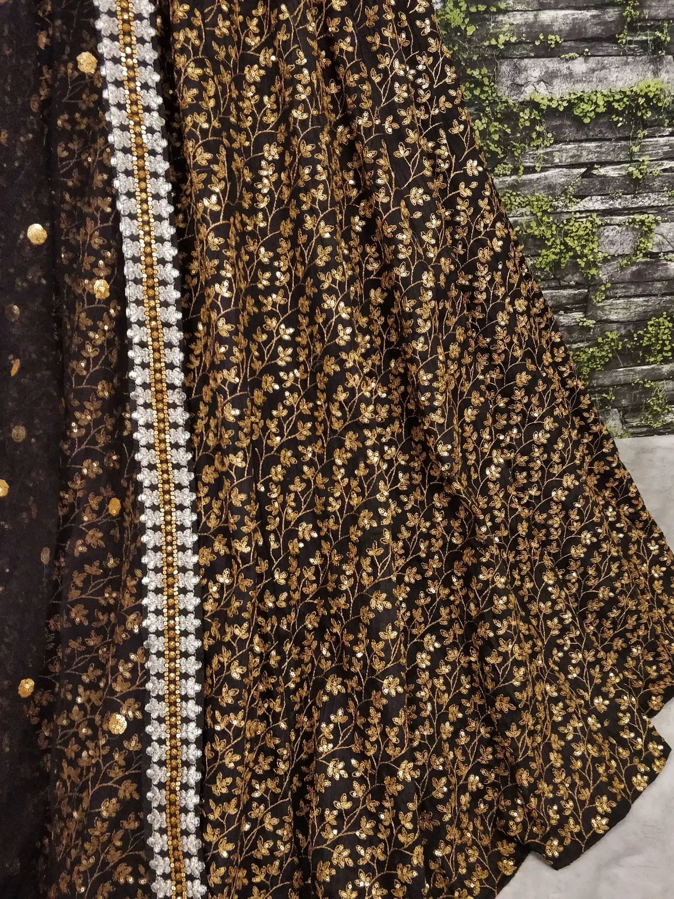 Black and gold embroidered lehenga with floral sequin work and silver border, ideal for Indian ethnic wear