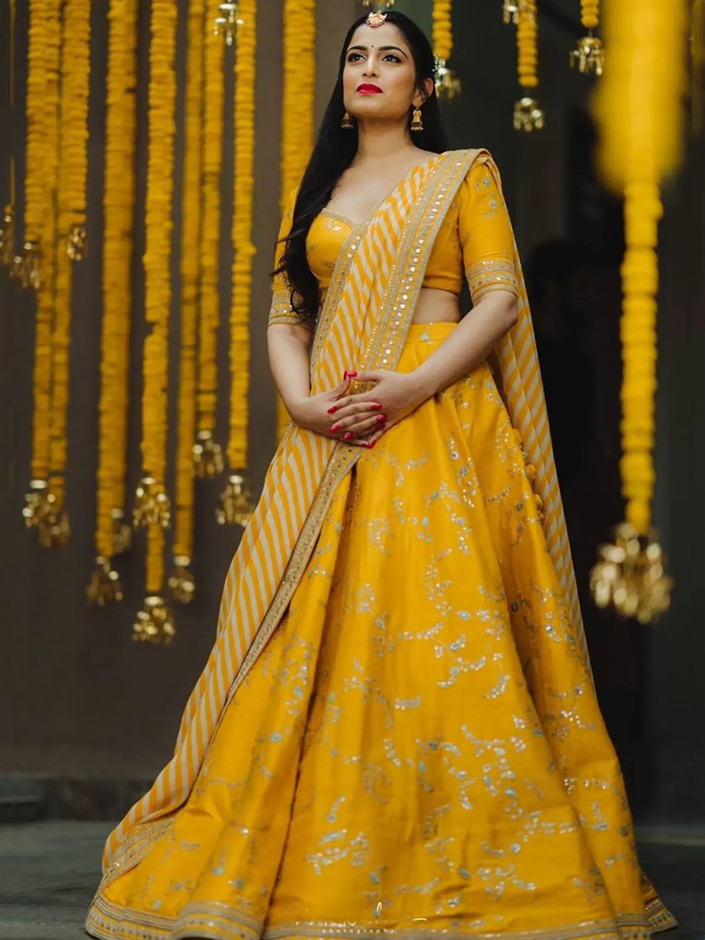 Yellow designer lehenga choli with gold embroidery, perfect for Indian weddings and festive occasions.