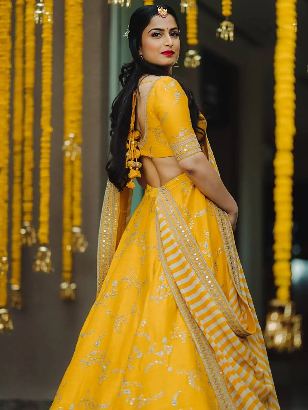 Yellow designer lehenga choli with backless blouse, perfect for Indian weddings and festive occasions