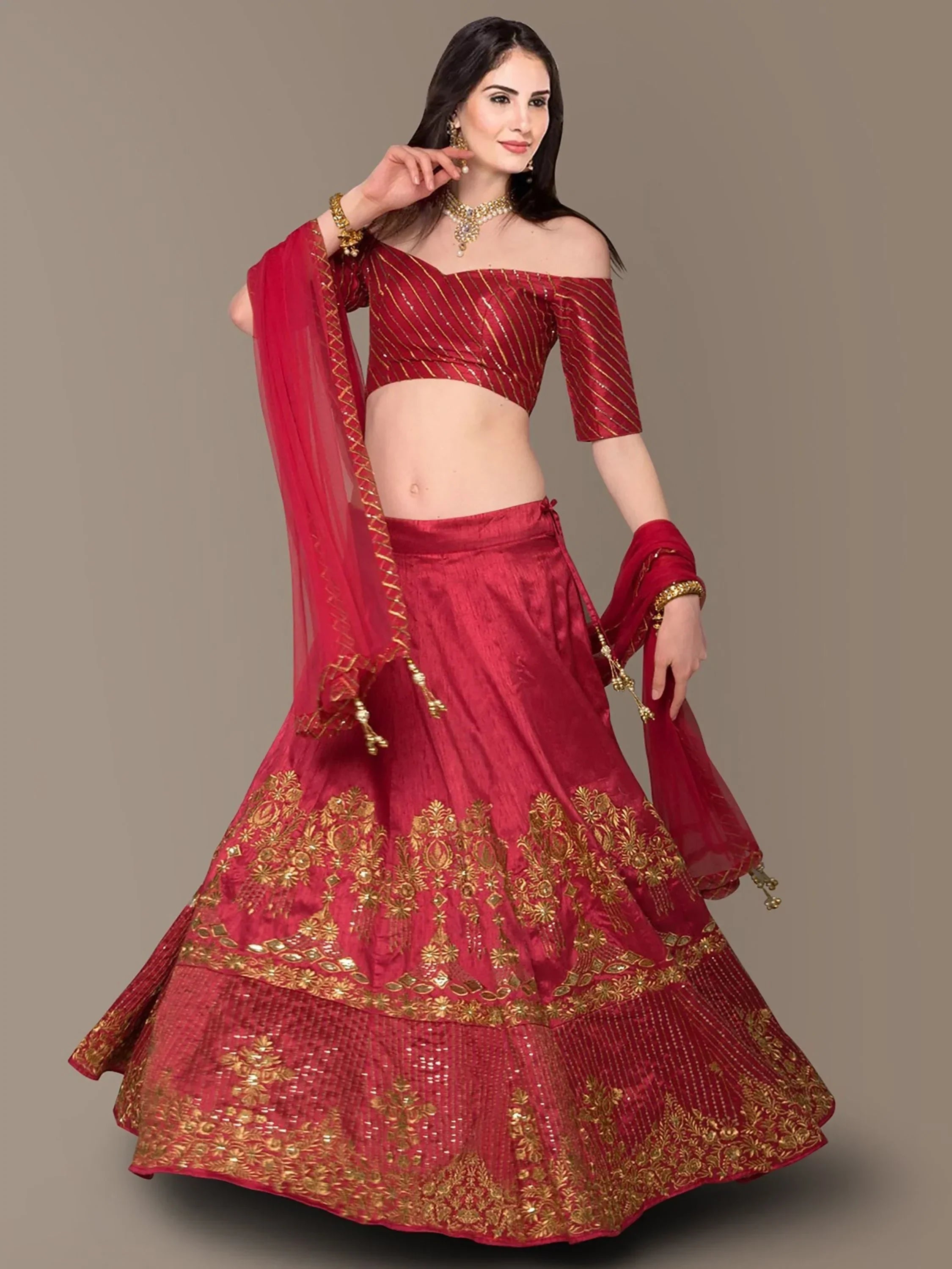 Red and gold embroidered lehenga choli with off-shoulder blouse and dupatta, perfect for Indian weddings and festivals.
