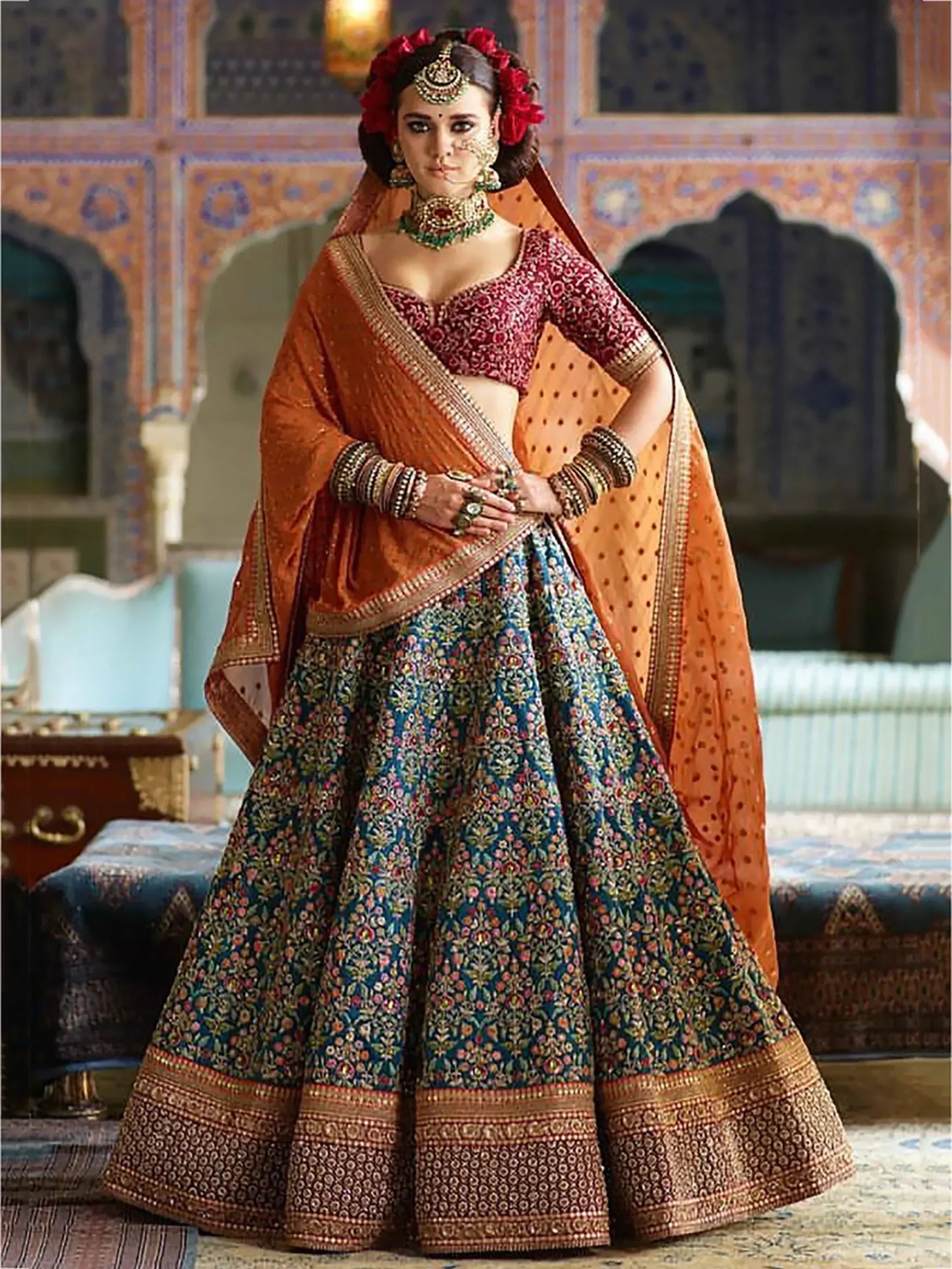 Elegant Indian bridal lehenga choli with floral embroidery, orange dupatta, and traditional jewelry