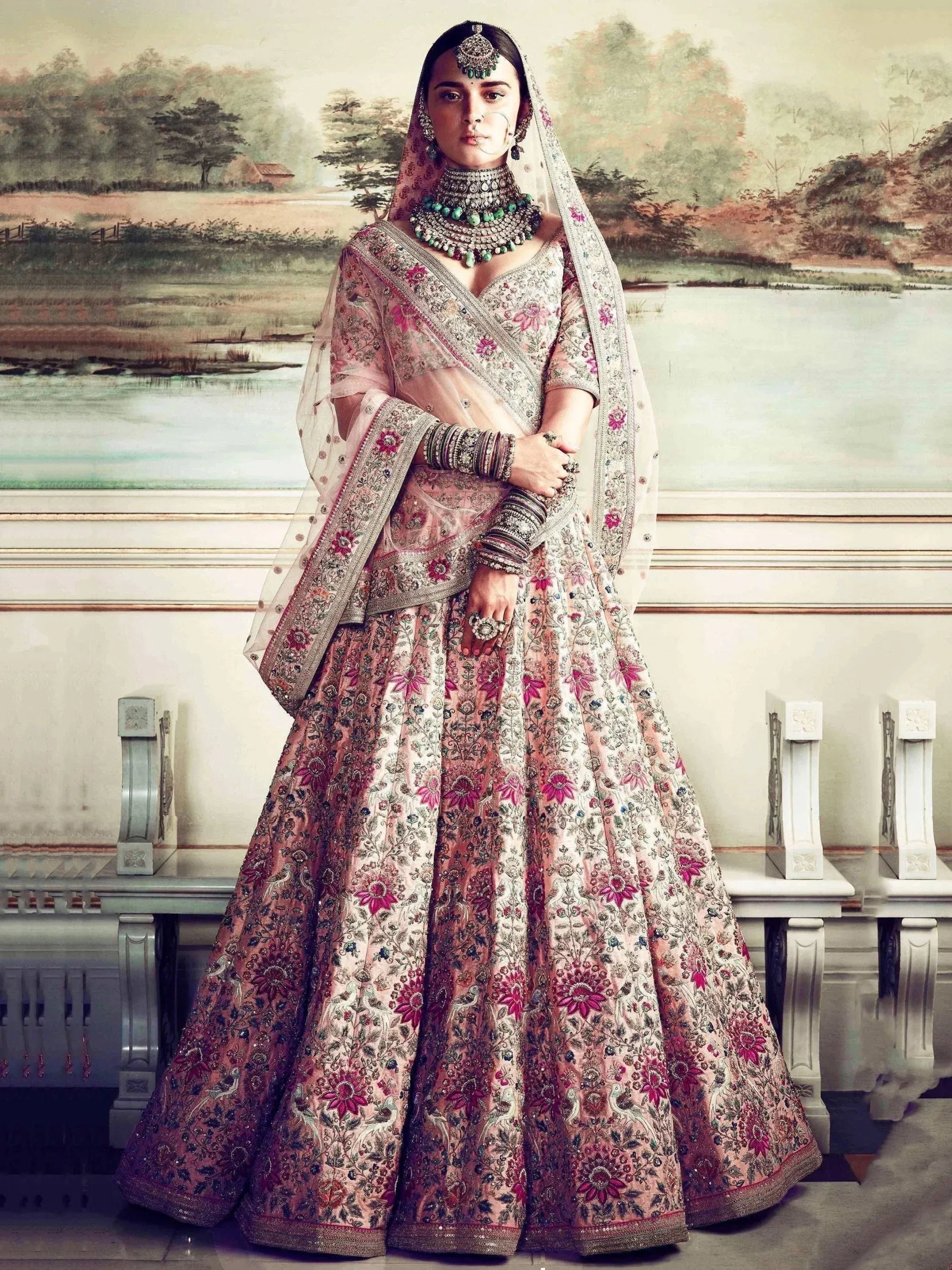 Elegant pink floral embroidered lehenga choli with heavy jewelry and dupatta, perfect for Indian weddings.